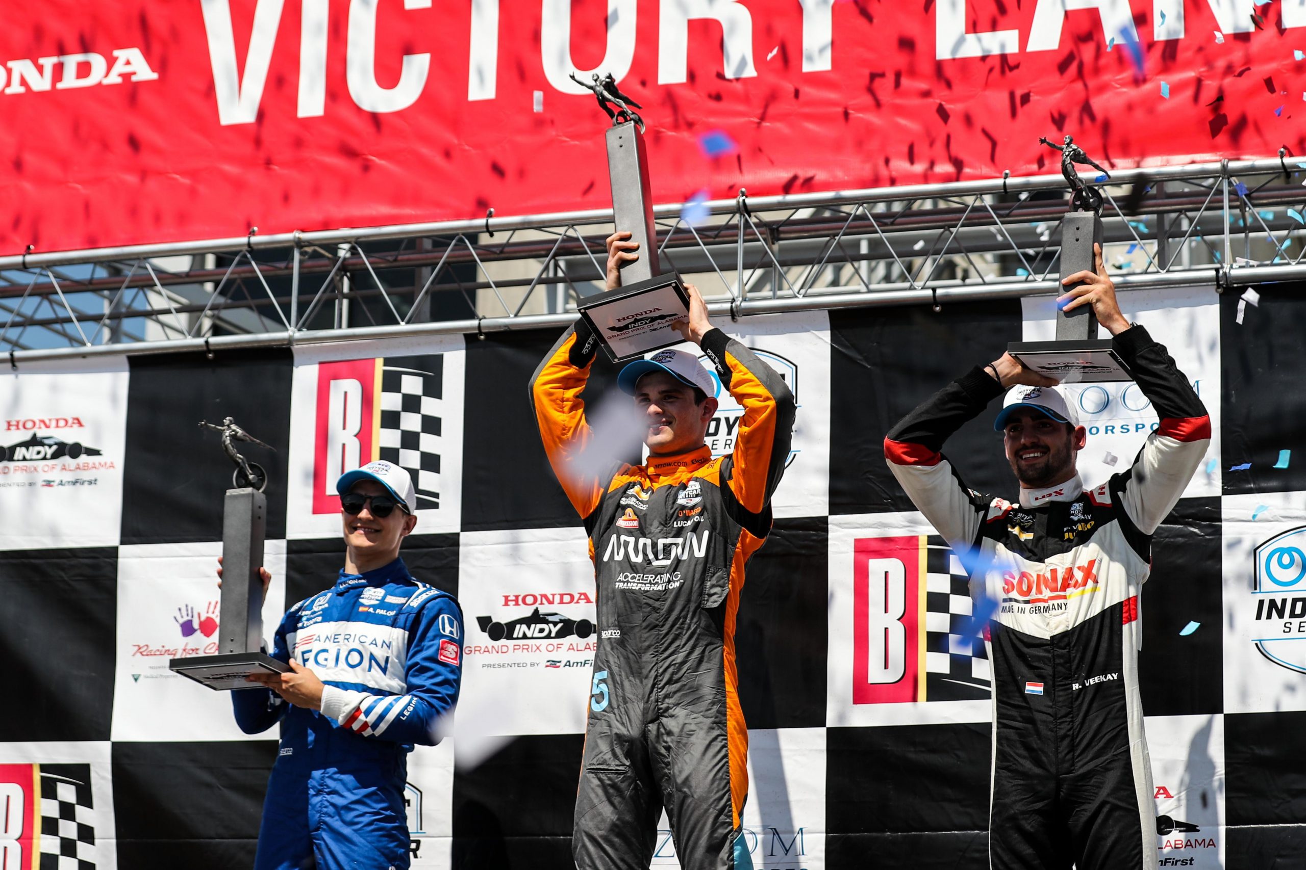 Alex Palou (from left), Pato O'Ward, and Rinus VeeKay stand on the Barber podium,
