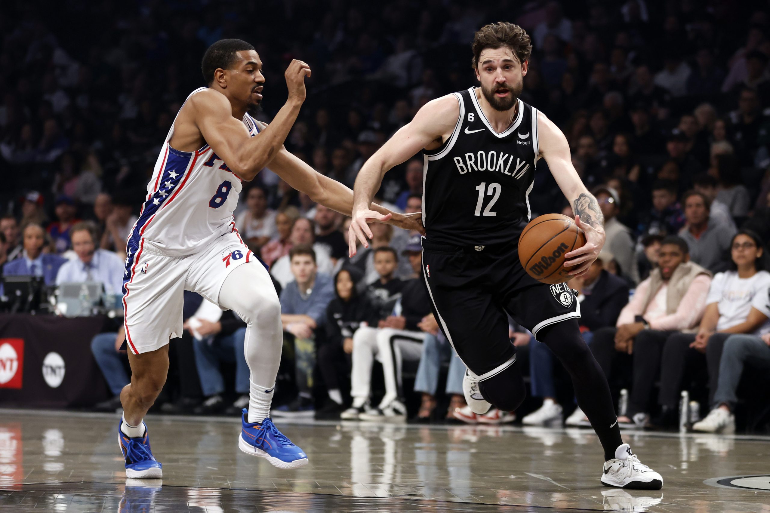 Joe Harris #12 of the Brooklyn Nets dribbles against De'Anthony Melton #8 of the Philadelphia 76ers during the first half of Game Four of the Eastern Conference First Round Playoffs at Barclays Center on April 22, 2023 in the Brooklyn borough of New York City. 