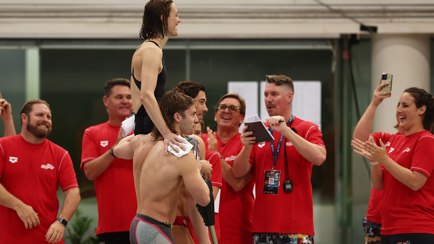 Ellie Cole is chaired off by teammates Matt Temple (L) and Grayson Bell (R) after swimming her final race at the 2022 Duel in the Pool at Sydney Olympic Park.