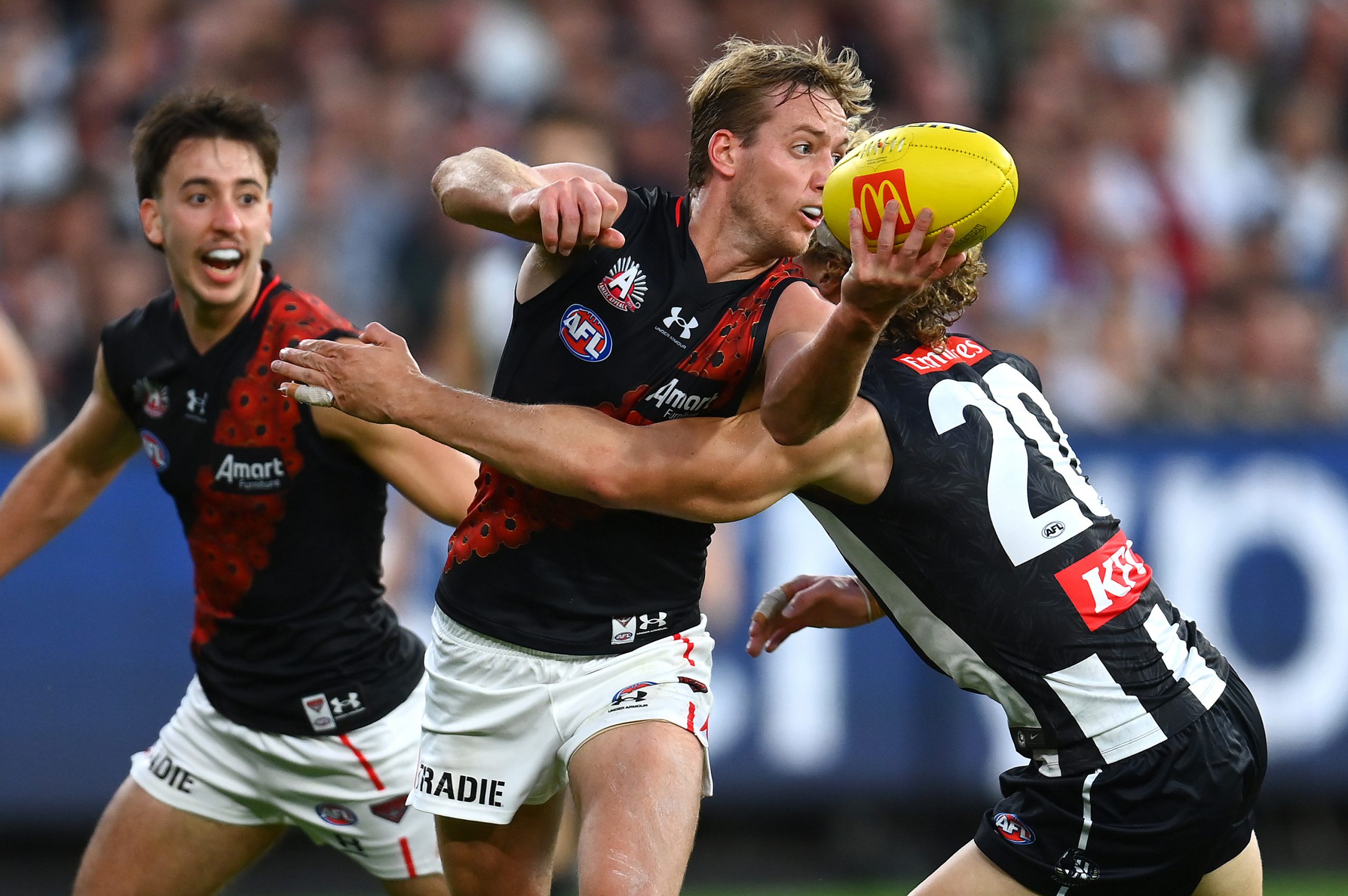 MELBOURNE, AUSTRALIA - APRIL 25: Darcy Parish of the Bombers handballs whilst being tackled by Will Kelly of the Magpies during the round six AFL match between Collingwood Magpies and Essendon Bombers at Melbourne Cricket Ground, on April 25, 2023, in Melbourne, Australia. (Photo by Quinn Rooney/Getty Images)