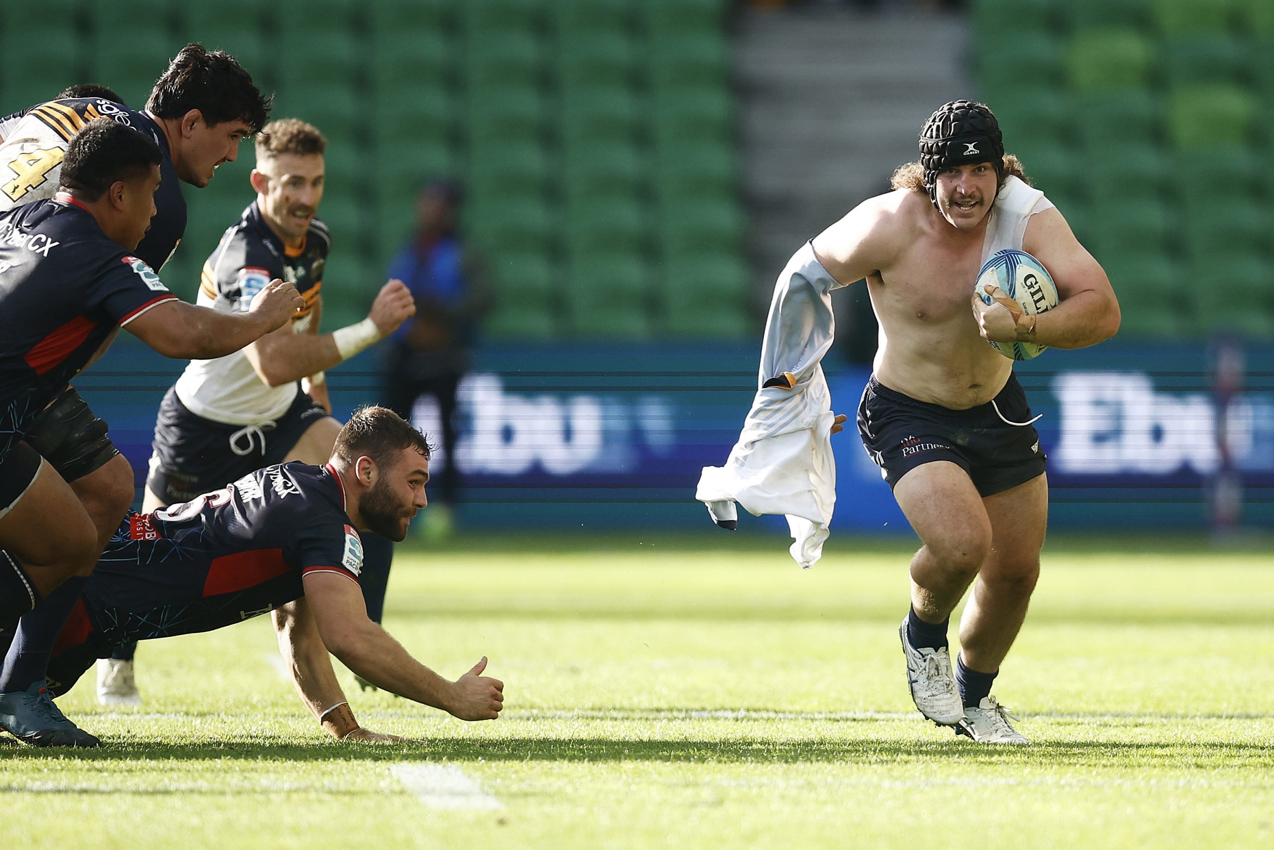 Lachlan Lonergan runs with ball in hand and his shirt tangled around his arm.