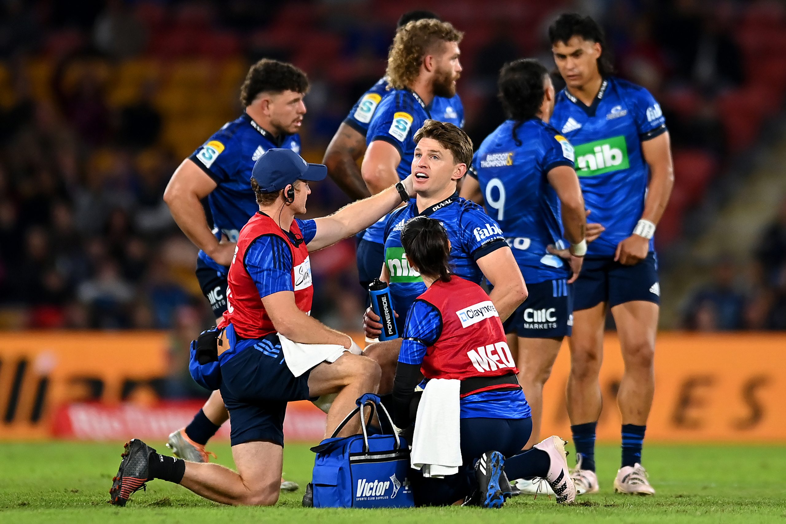 Beauden Barrett of the Blues receives attention from trainers during the round 13 Super Rugby Pacific match.