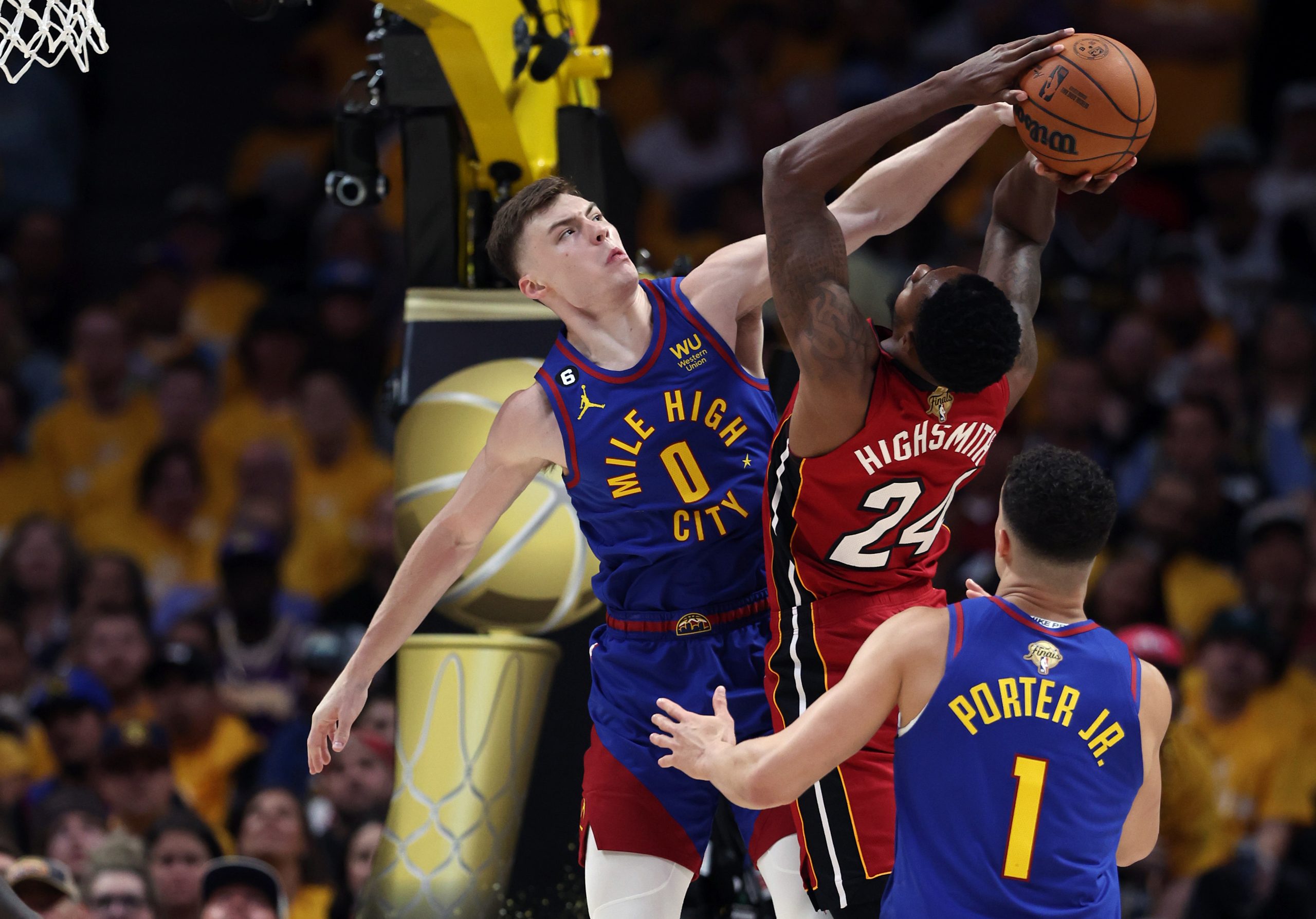 Christian Braun of the Denver Nuggets blocks a shot by Haywood Highsmith of the Miami Heat.