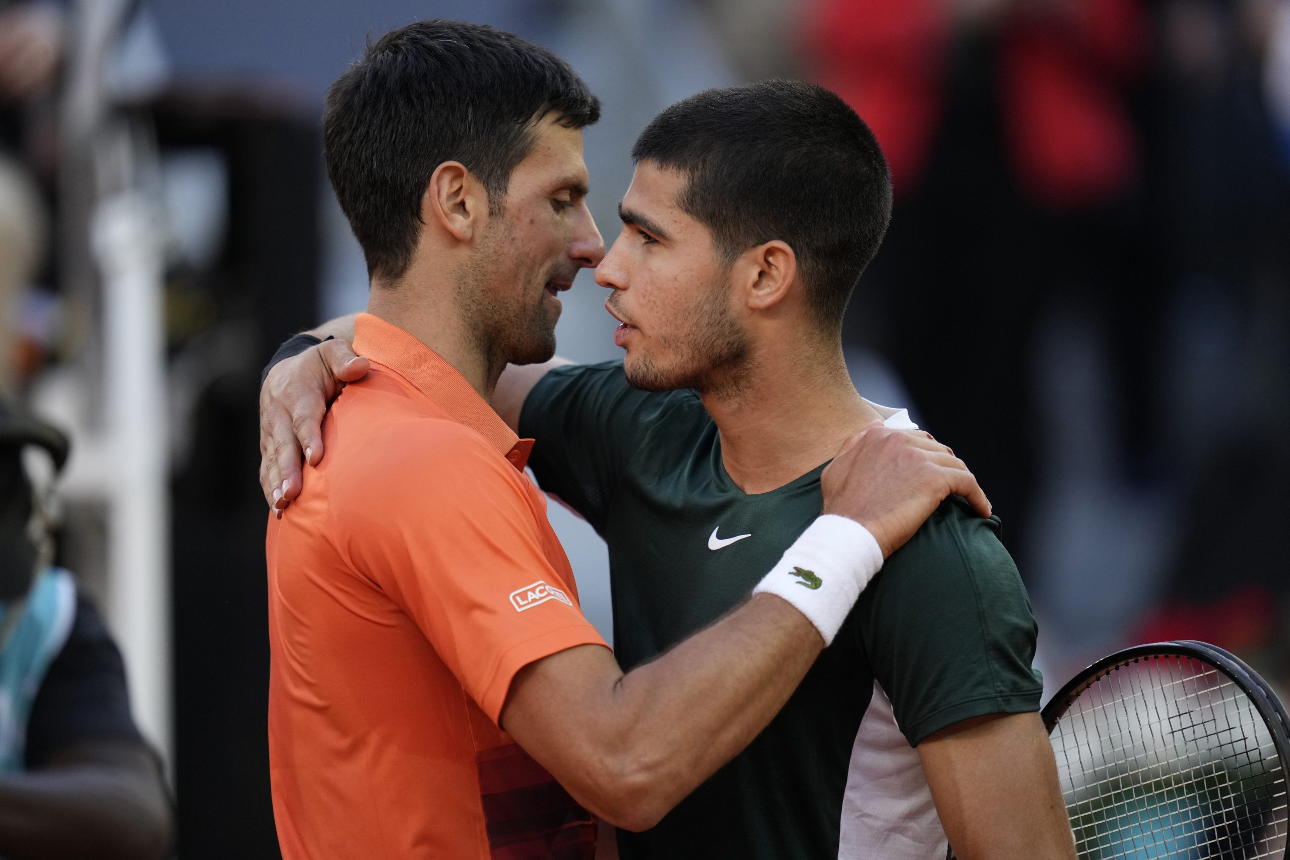 Novak Djokovic embraces Carlos Alcaraz at the Madrid Open.