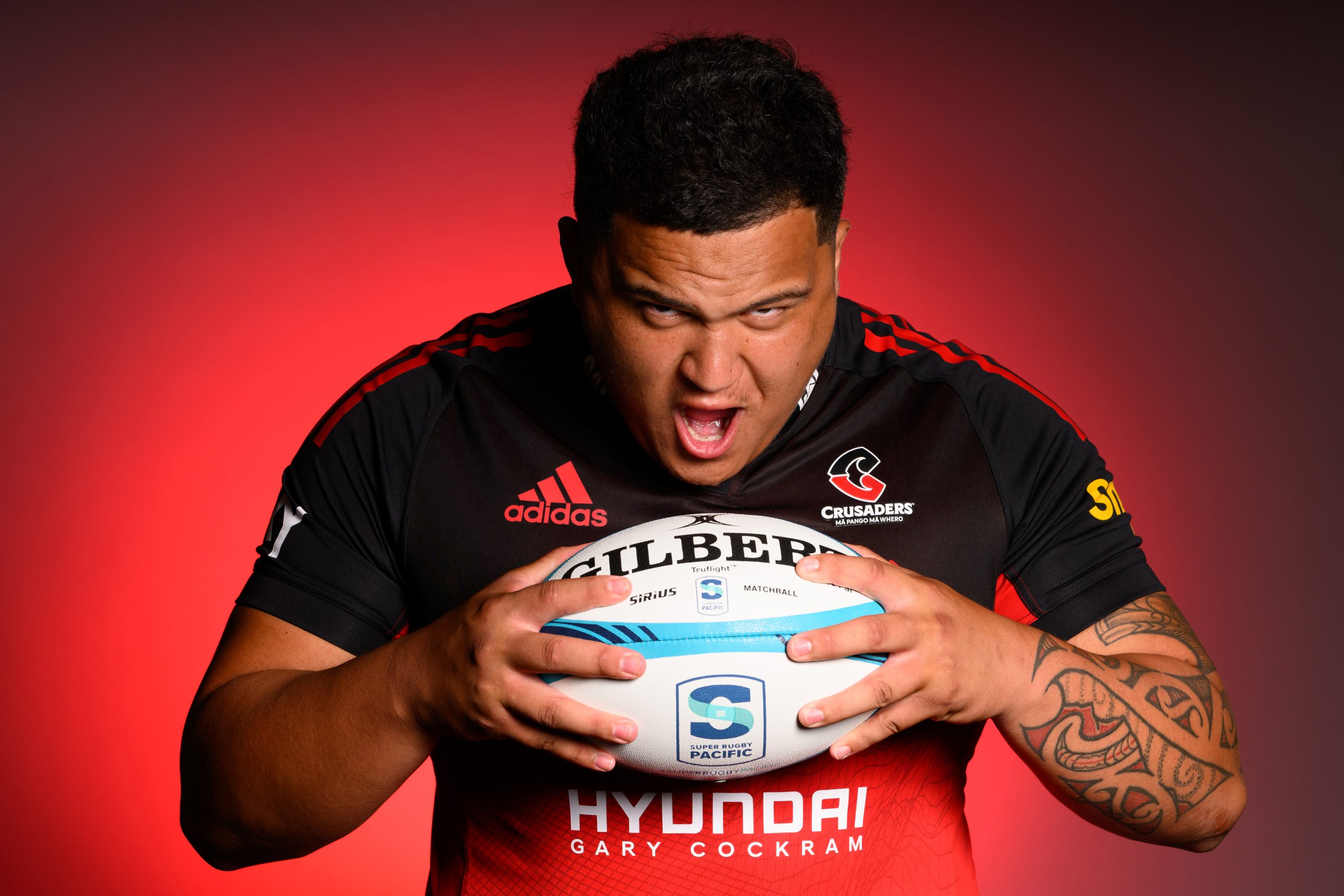 Crusaders prop Tamaiti Williams pretends to eat a rugby ball.