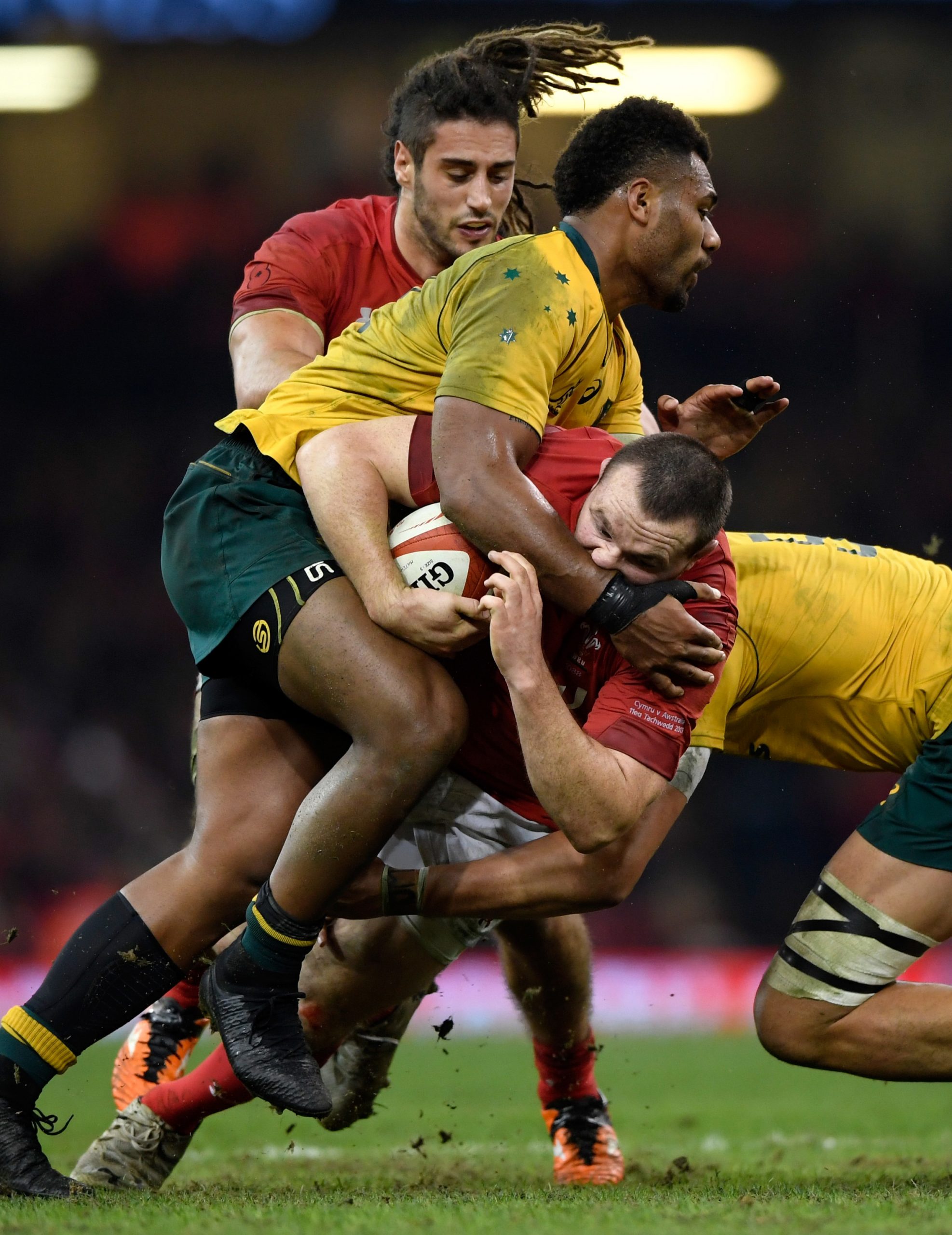 Samu Kerevi of Australia tackles Ken Owens as Josh Navidi looks on.