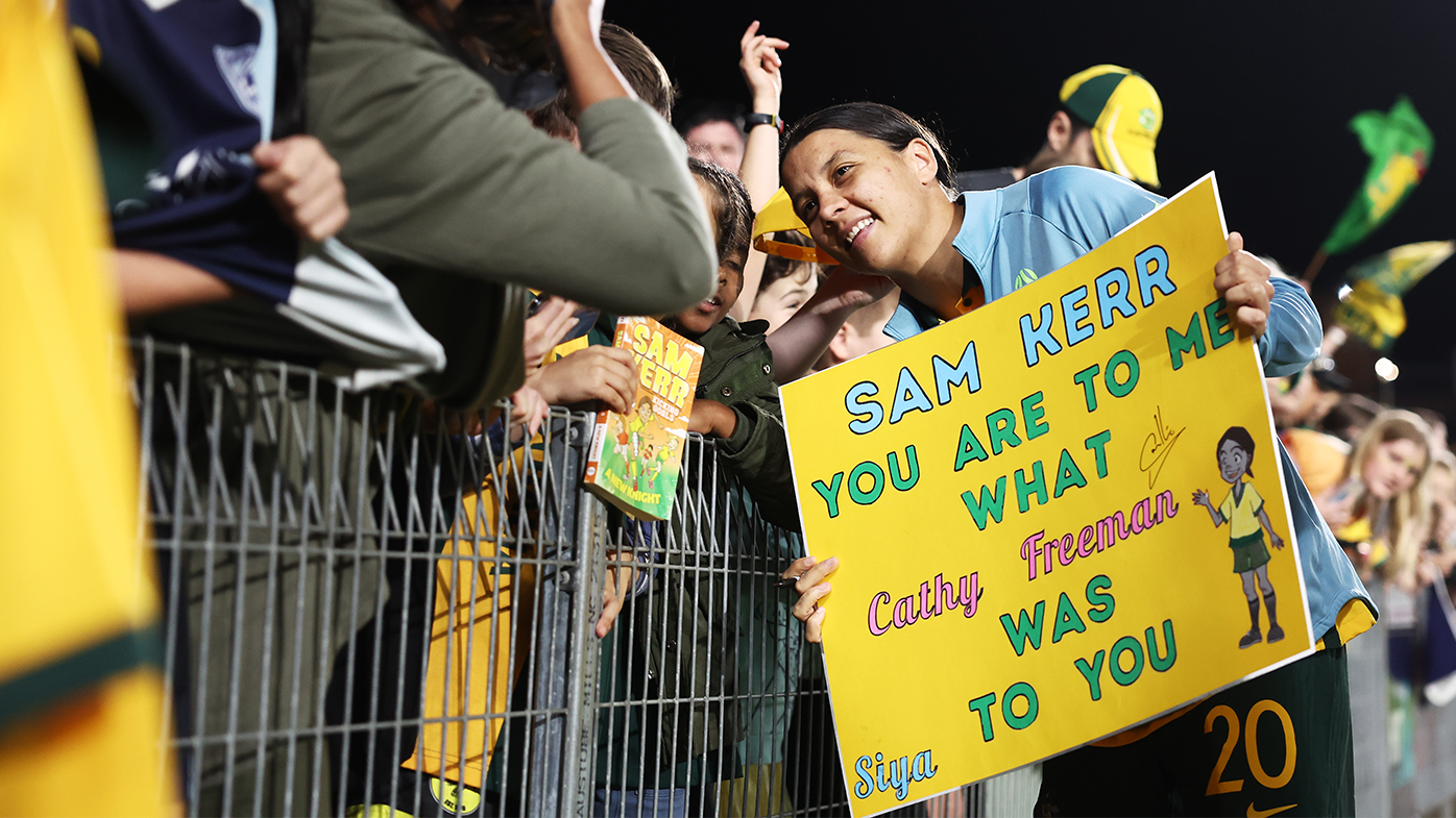 Sam Kerr interacts with a young fan after the Matildas' international friendly match with Thailand.