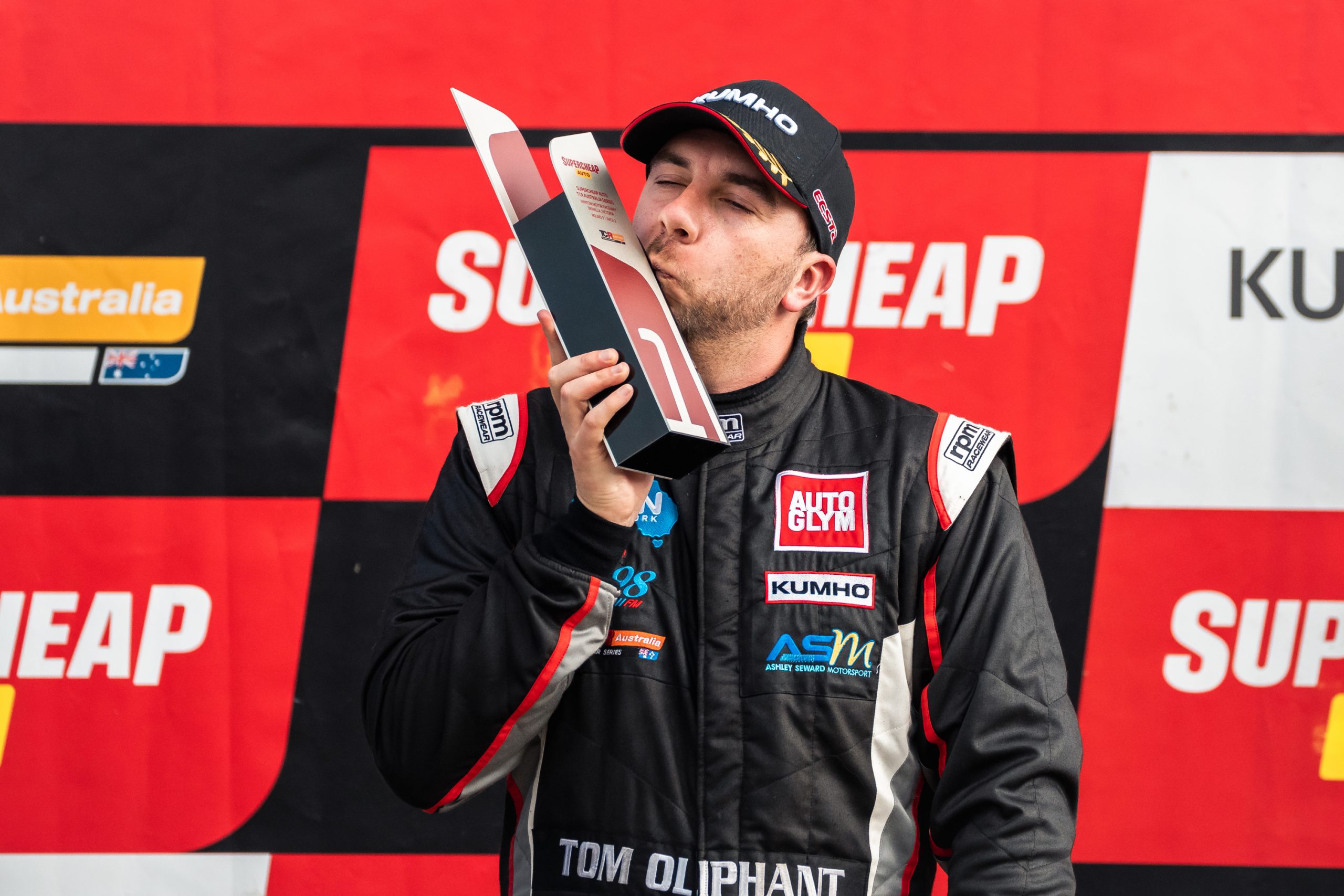 Tom Oliphant kisses his trophy after winning race two of the TCR Australia Series at Winton Motor Raceway.