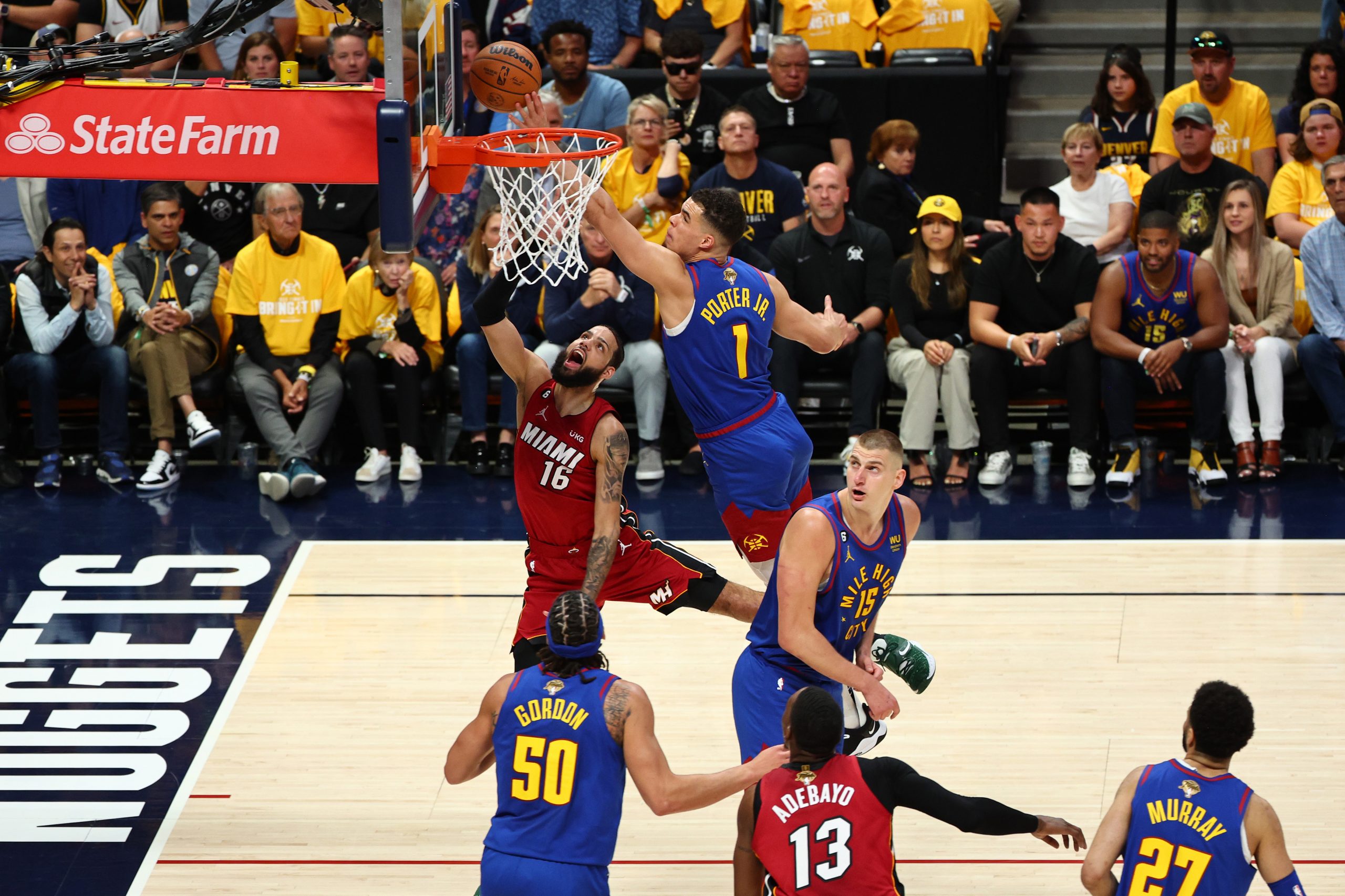 Caleb Martin of the Miami Heat drives to the basket against Michael Porter Jr of the Denver Nuggets.