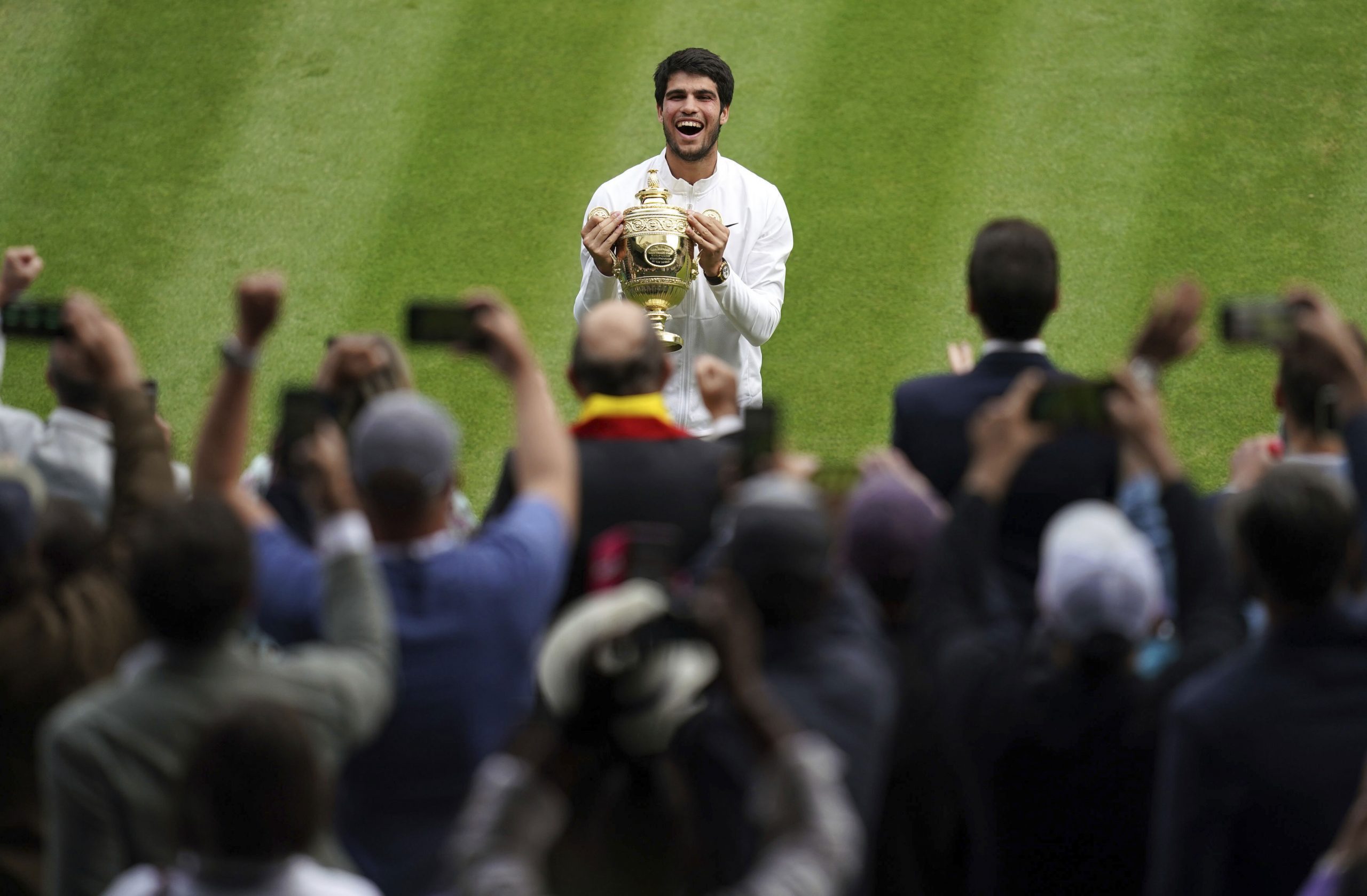 Spain's Carlos Alcaraz celebrates with the trophy after beating Serbia's Novak Djokovic to win the final of the mens singles at Wimbledon.