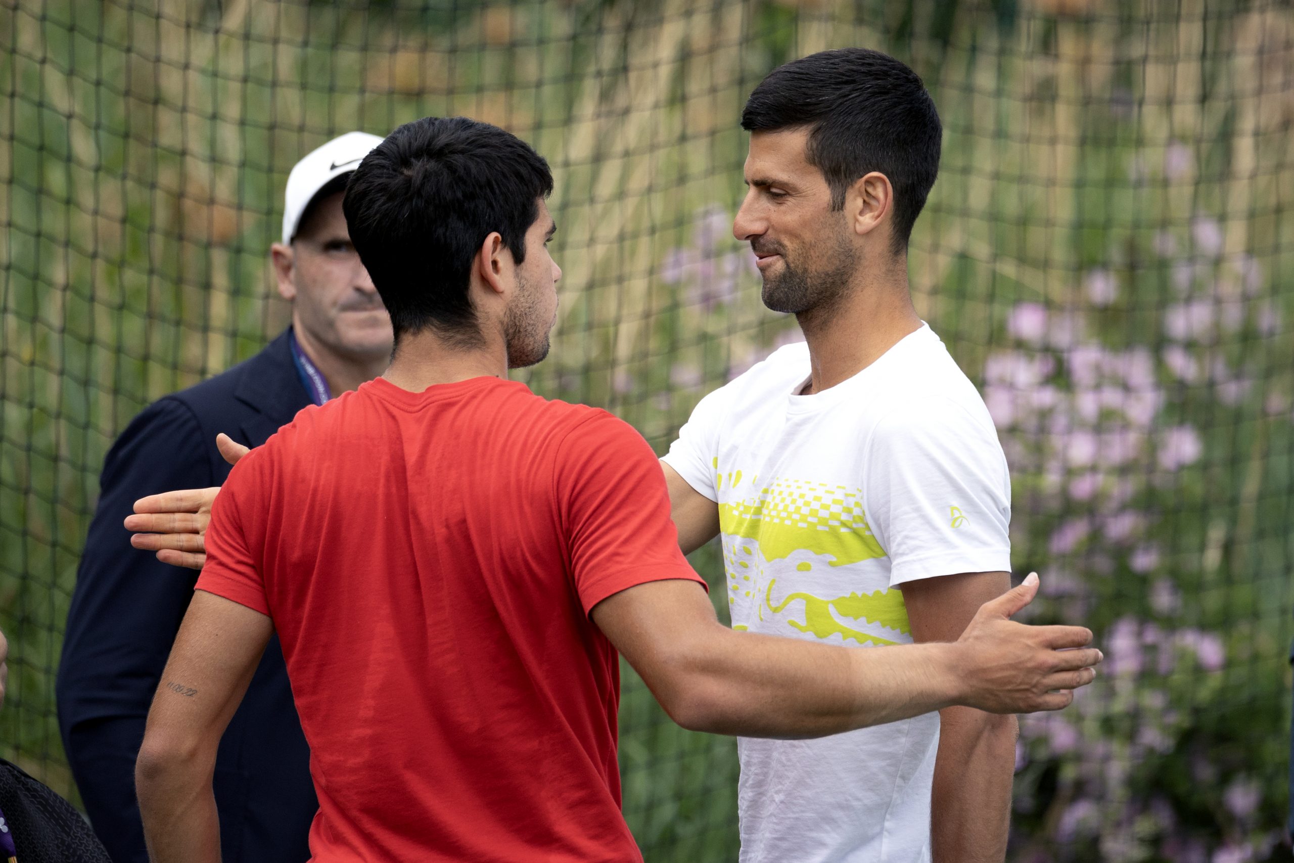 Carlos Alcaraz of Spain and Novak Djokovic of Serbia embrace during court changeover as players train on the practice courts in preparation for the Wimbledon Lawn Tennis Championships at the All England Lawn Tennis and Croquet Club at Wimbledon on July 02, 2023, in London, England. (Photo by Tim Clayton/Corbis via Getty Images)