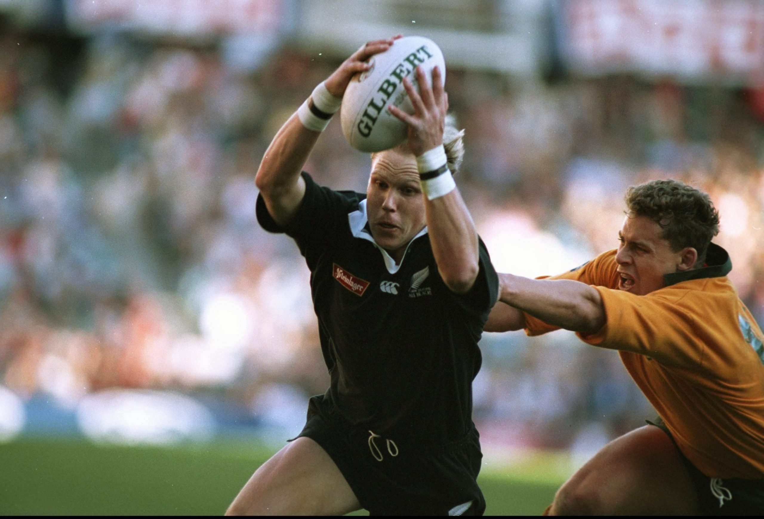 Jeff Wilson of New Zealand shakes off Jason Little of Australia to score.