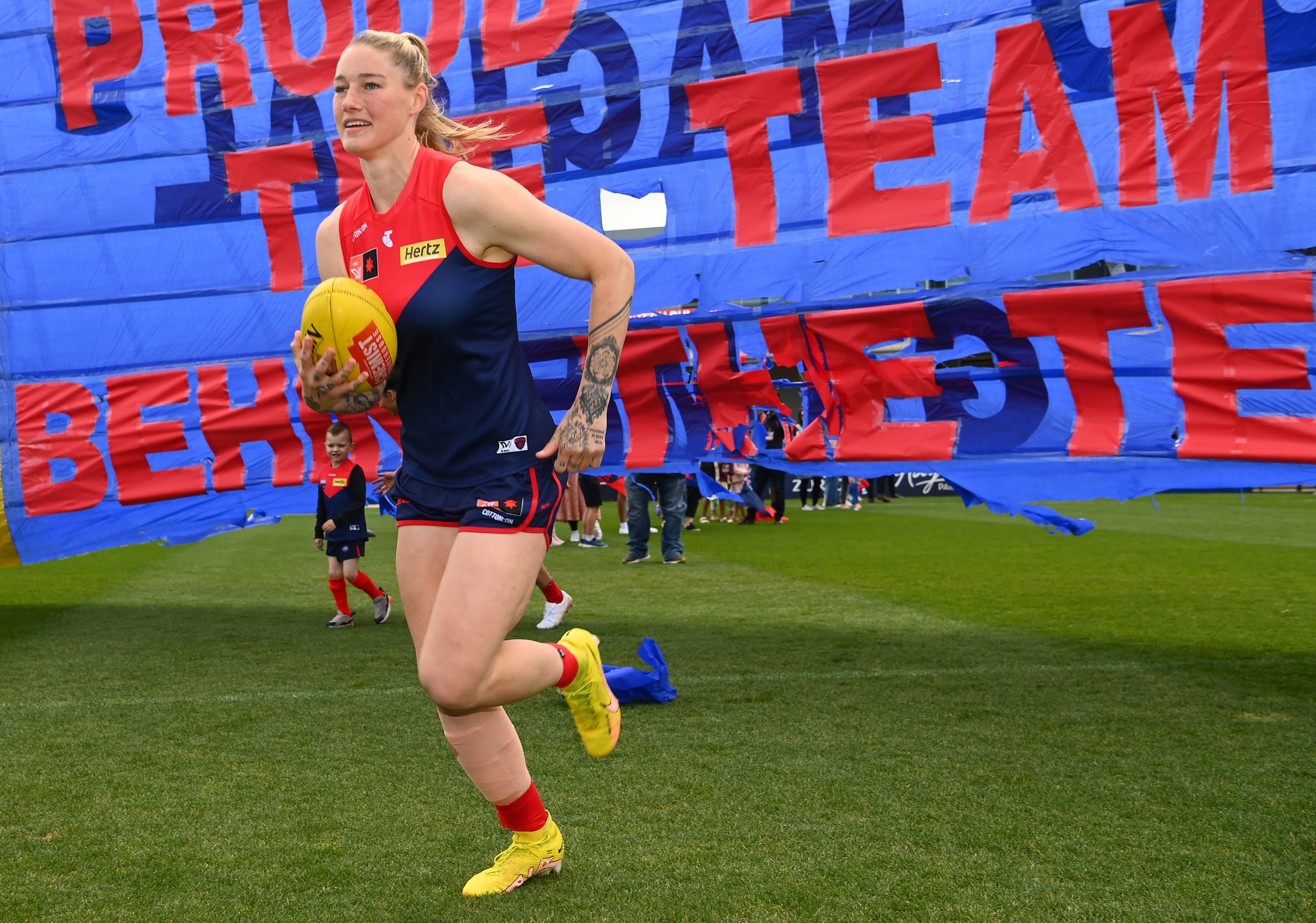 Tayla Harris of the Demons runs through the banner during the round seven AFLW match between the Melbourne Demons and the Western Bulldogs at Casey Fields on October 09, 2022 in Melbourne, Australia.
