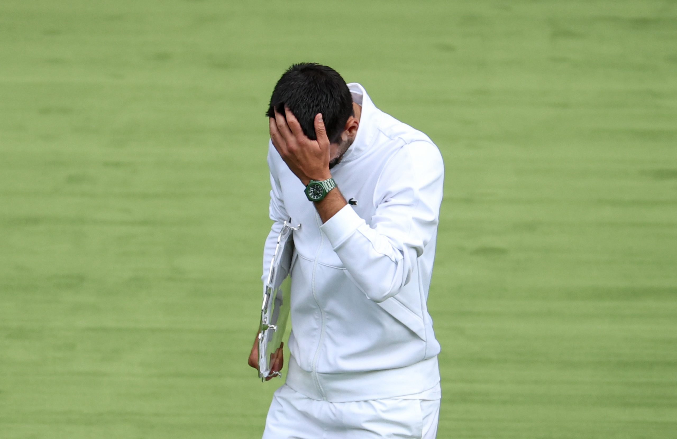 Novak Djokovic puts his head in his hand in the men's final at Wimbledon.