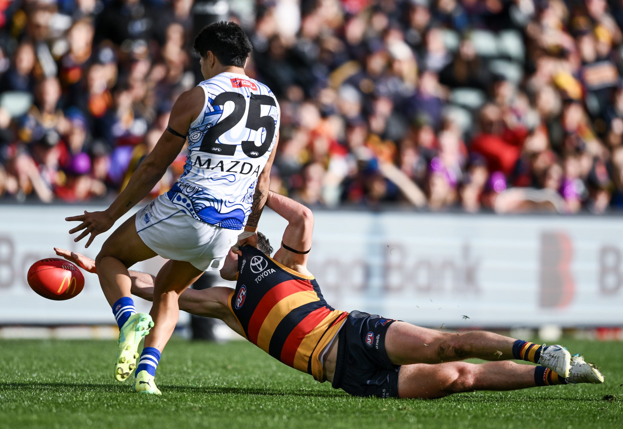 Chayce Jones of the Crows smothers Paul Curtis' kick for goal during the round 16 AFL match between Adelaide Crows and North Melbourne Kangaroos.