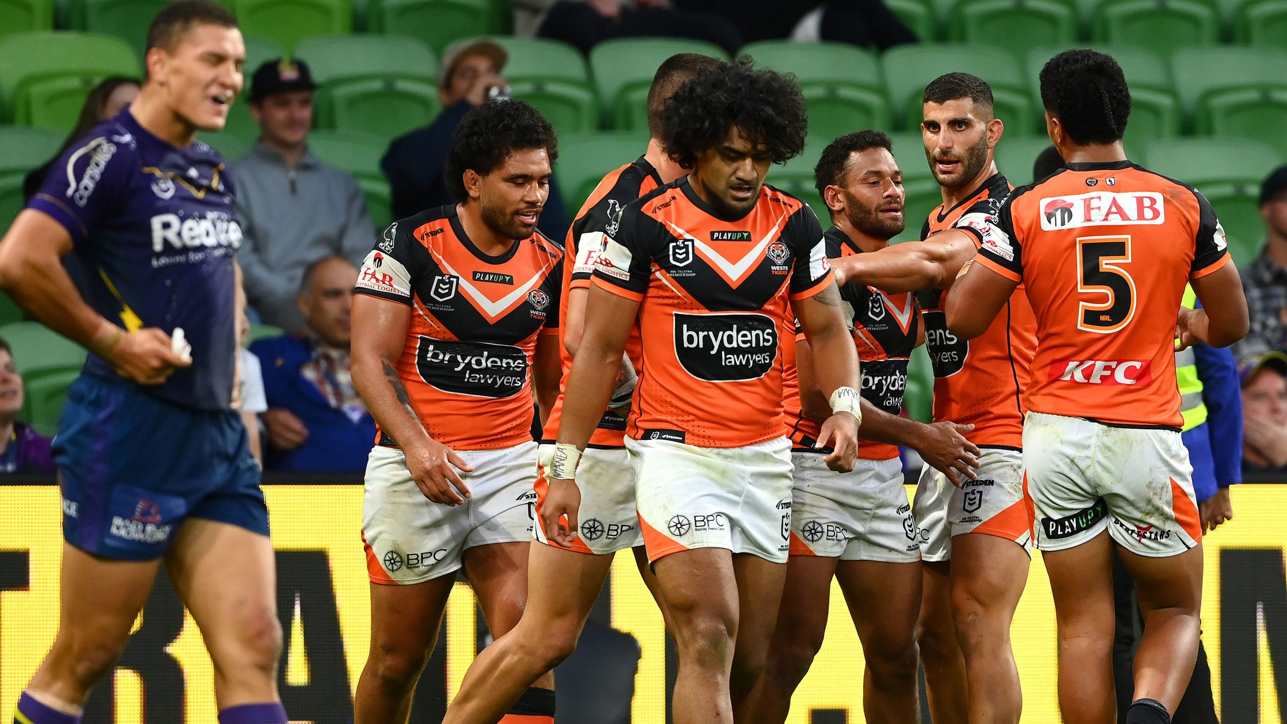 Apisai Koroisau celebrates with Tigers teammates after scoring a try during their round four NRL match against the Melbourne Storm.