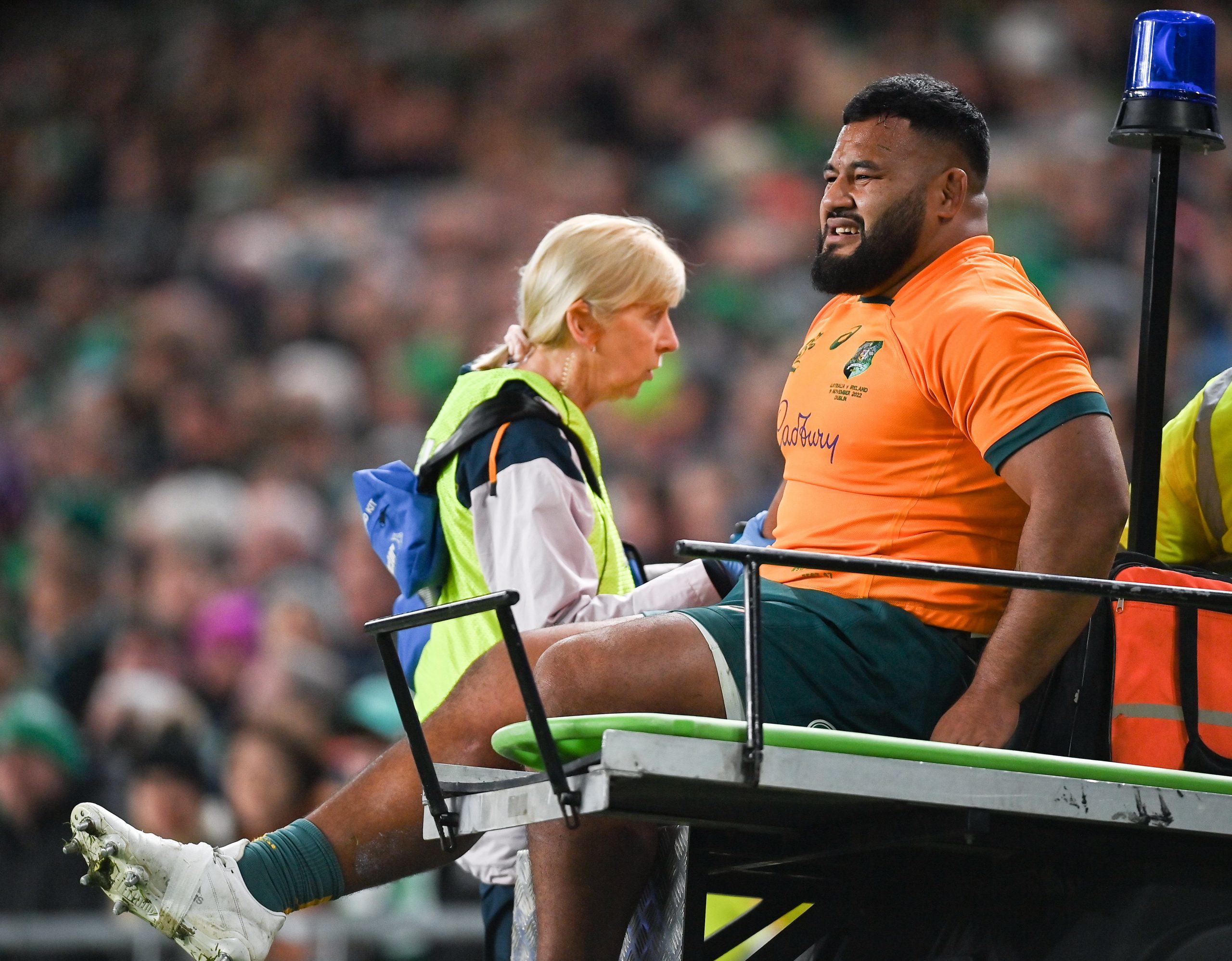 Taniela Tupou of Australia is taken from the pitch to receive medial attention.