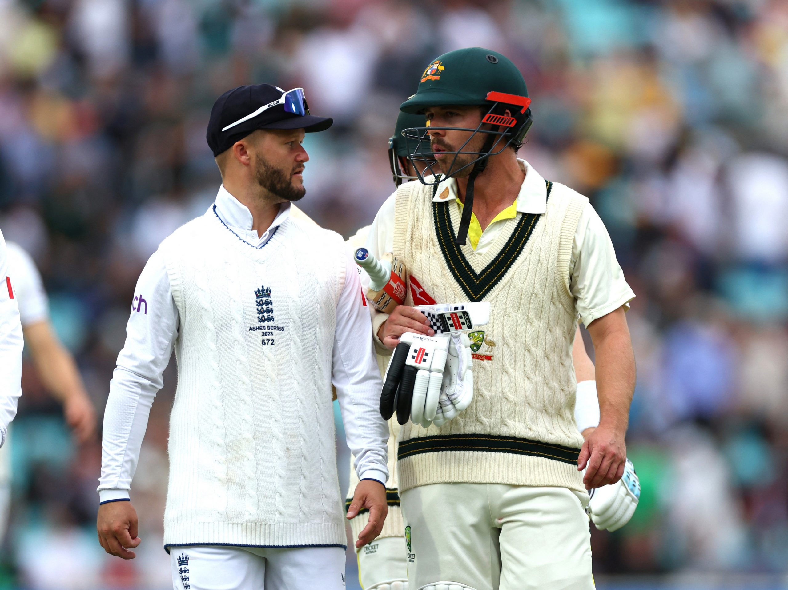 Australia's Travis Head speaks to England's Ben Duckett as they leave the field for lunch at The Oval.