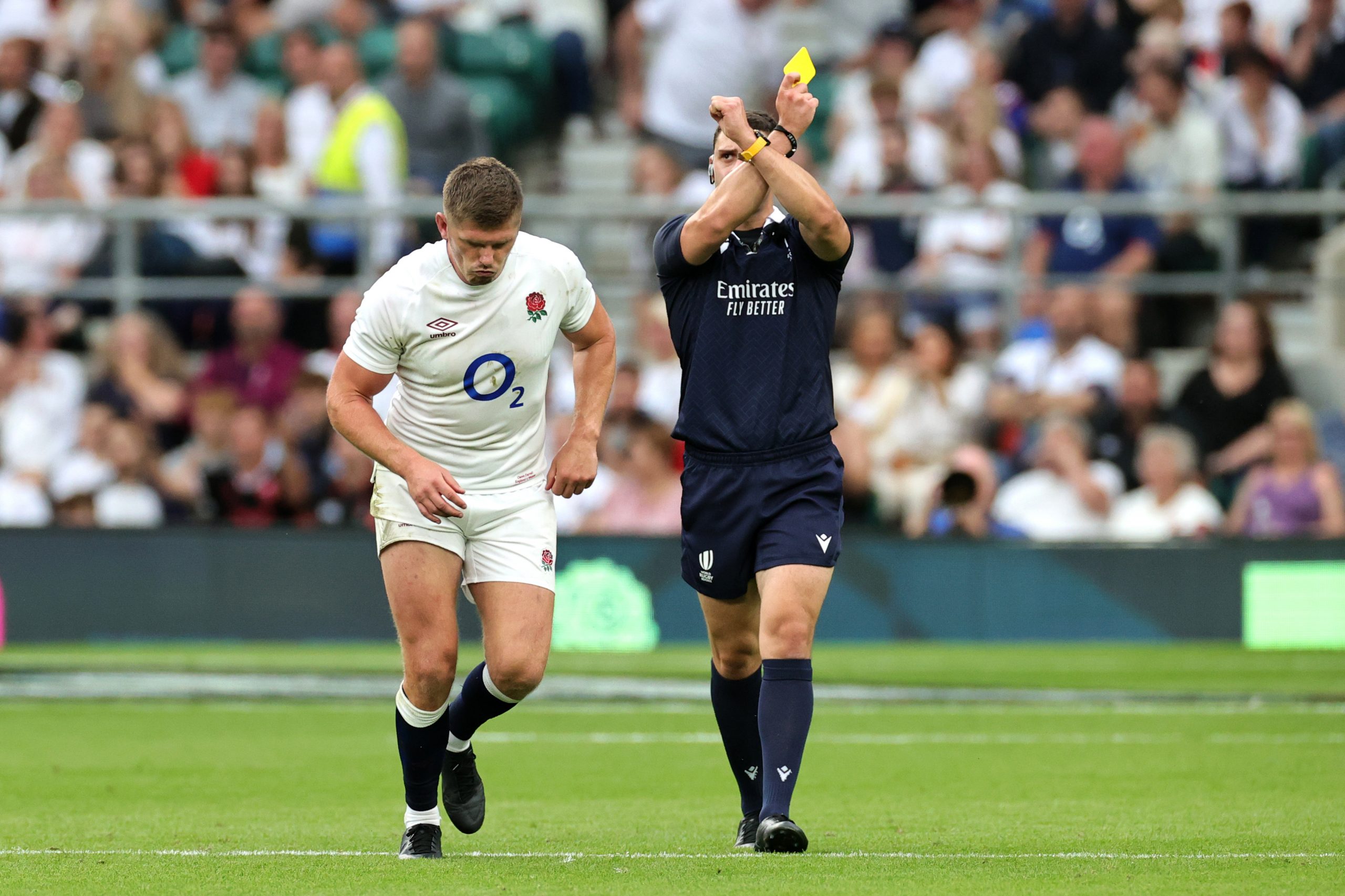 Owen Farrell receives a yellow card from referee Nika Amashukeli after a high tackle on Taine Basham of Wales.