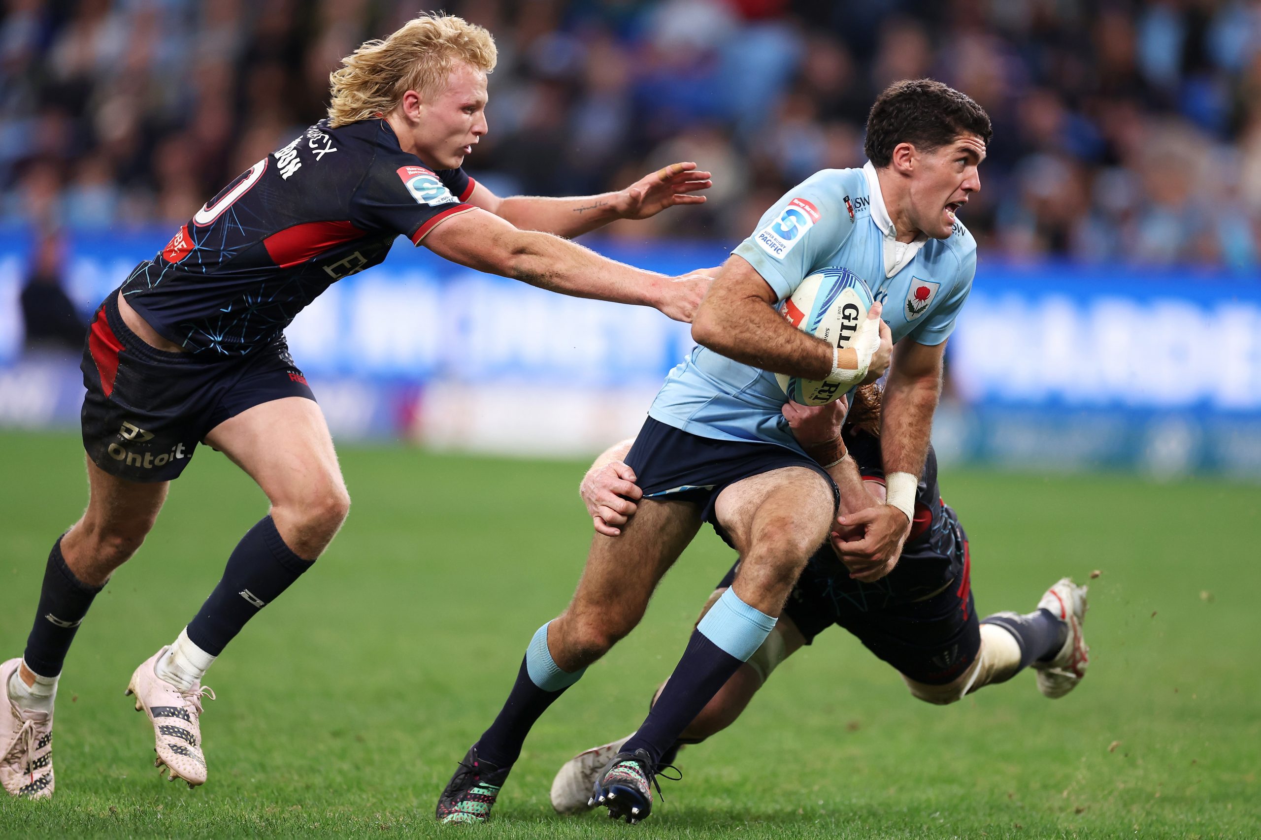 Ben Donaldson of the NSW Waratahs is tackled by Melbouirne Rebels Carter Gordon.