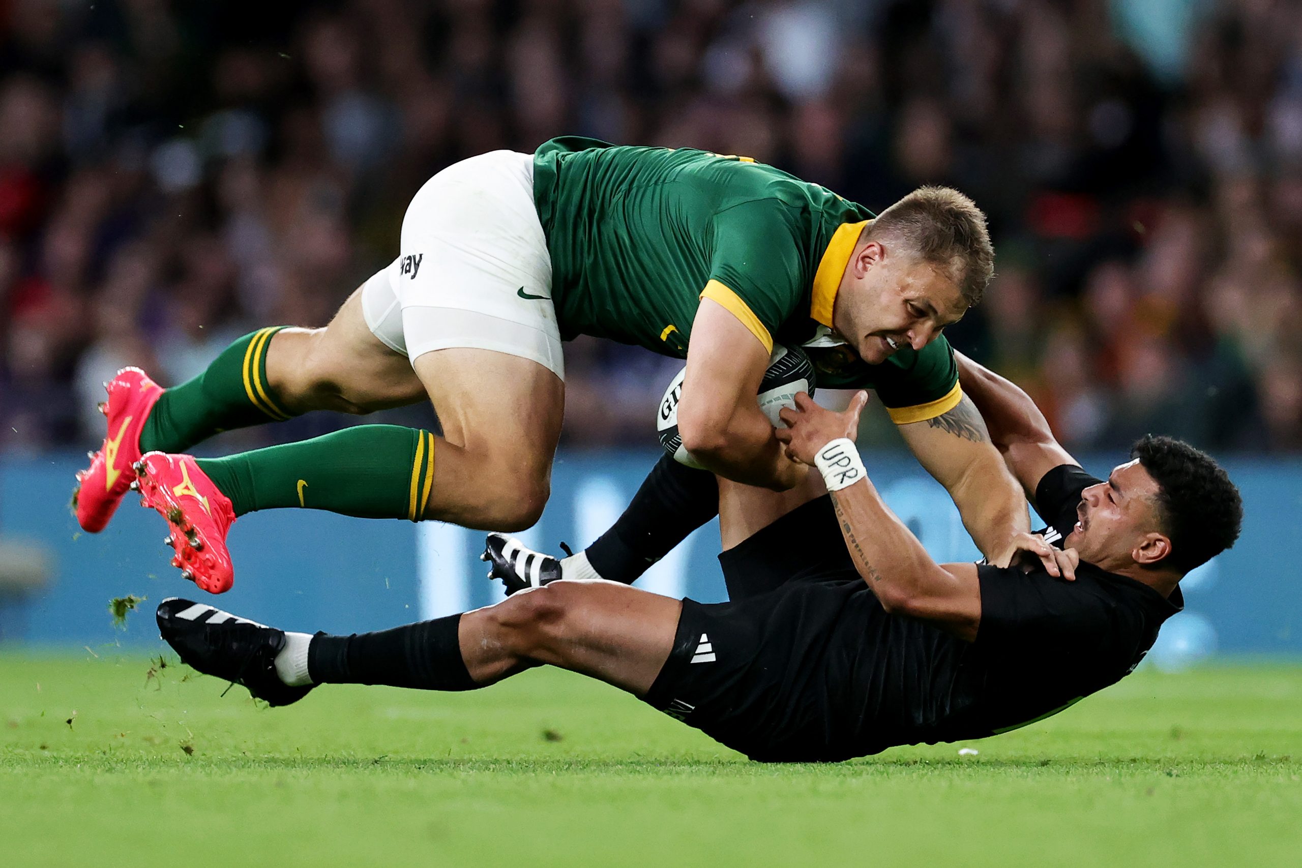 Andre Esterhuizen of South Africa is tackled by Richie Mo'unga of New Zealand.