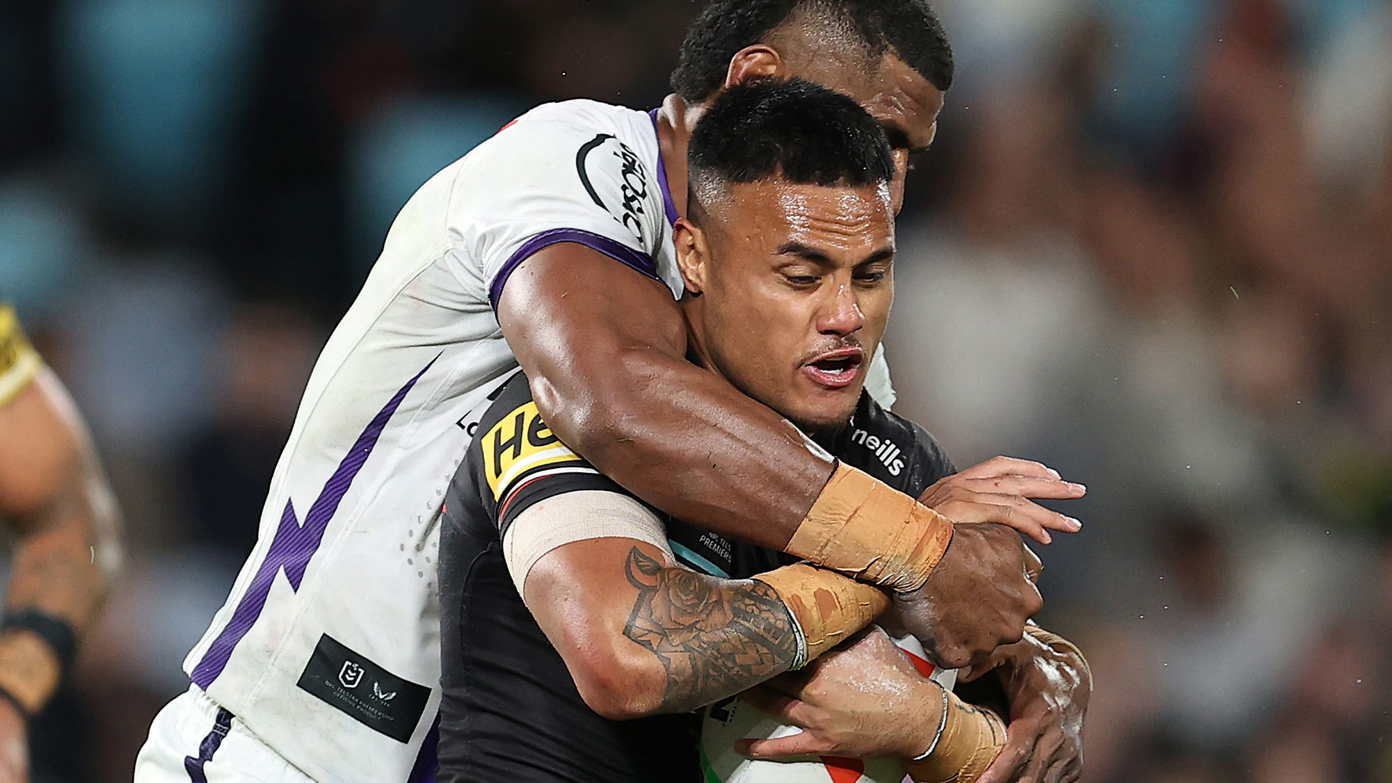 Spencer Leniu of the Panthers is tackled by Tui Kamikamica of the Storm during their preliminary final battle.