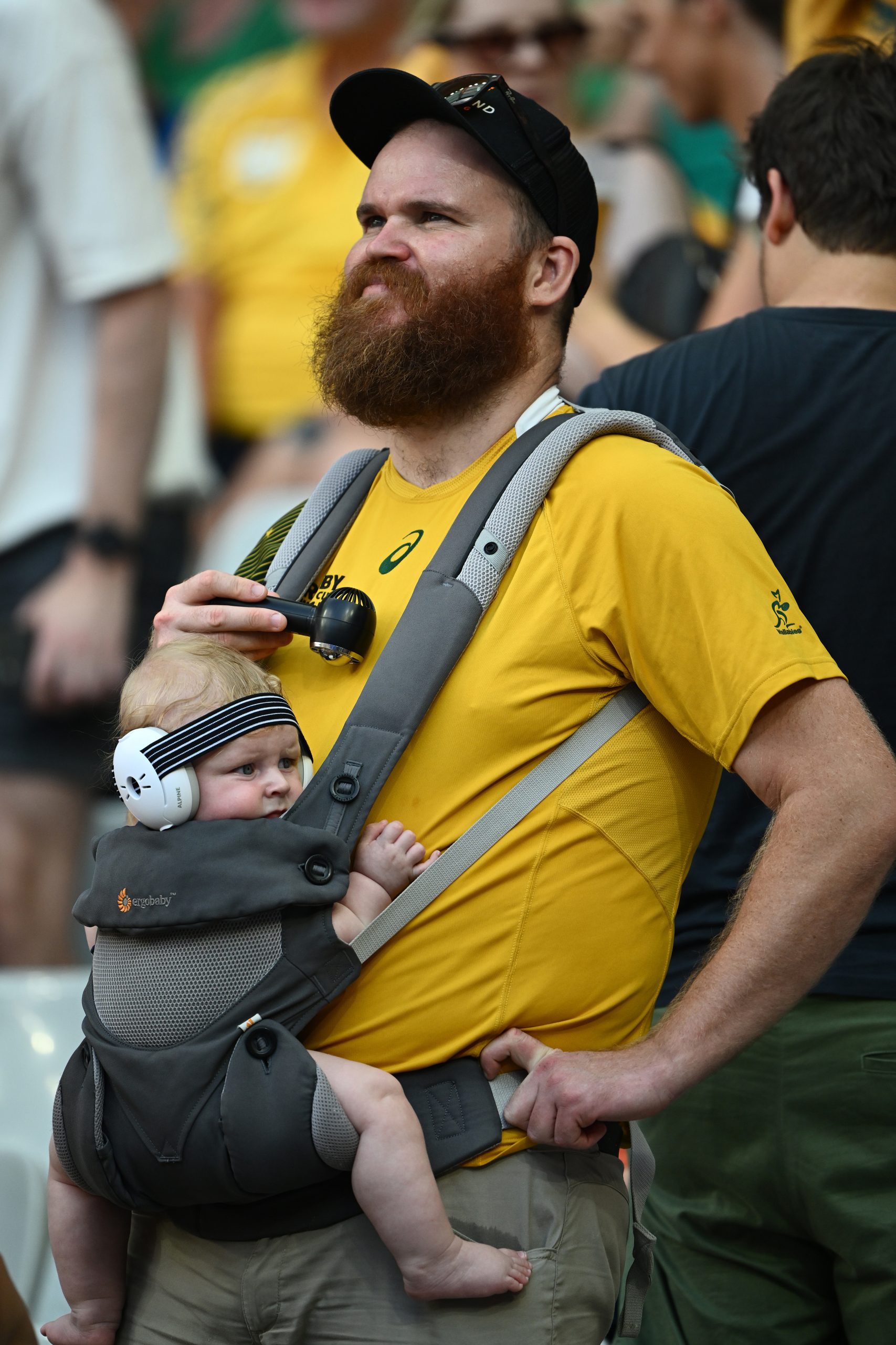 An Australian fan cools his baby in the stifling heat at Stade de France.