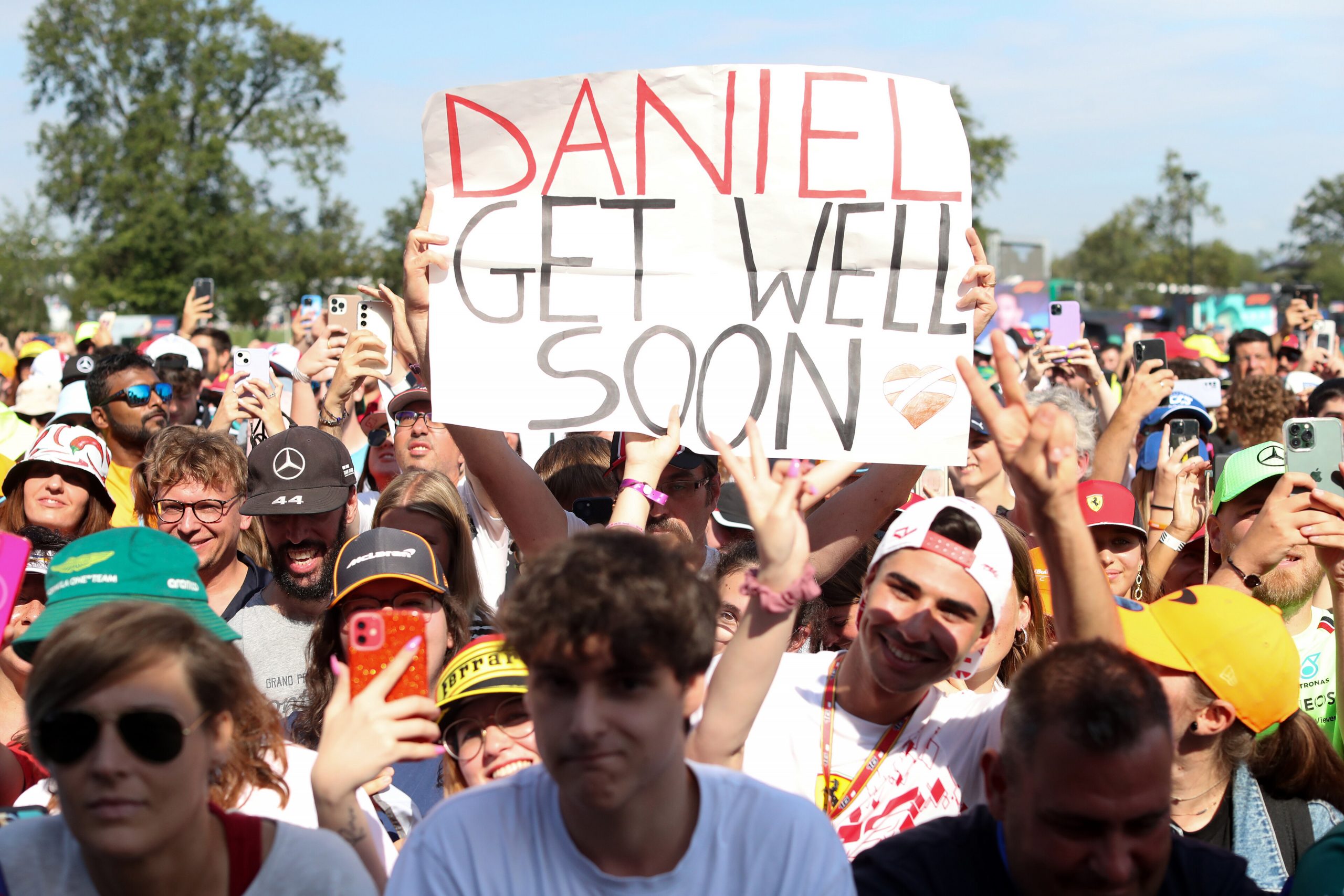 A fan holds a sign wishing the injured Daniel Ricciardo a speedy recovery after he broke his hand.