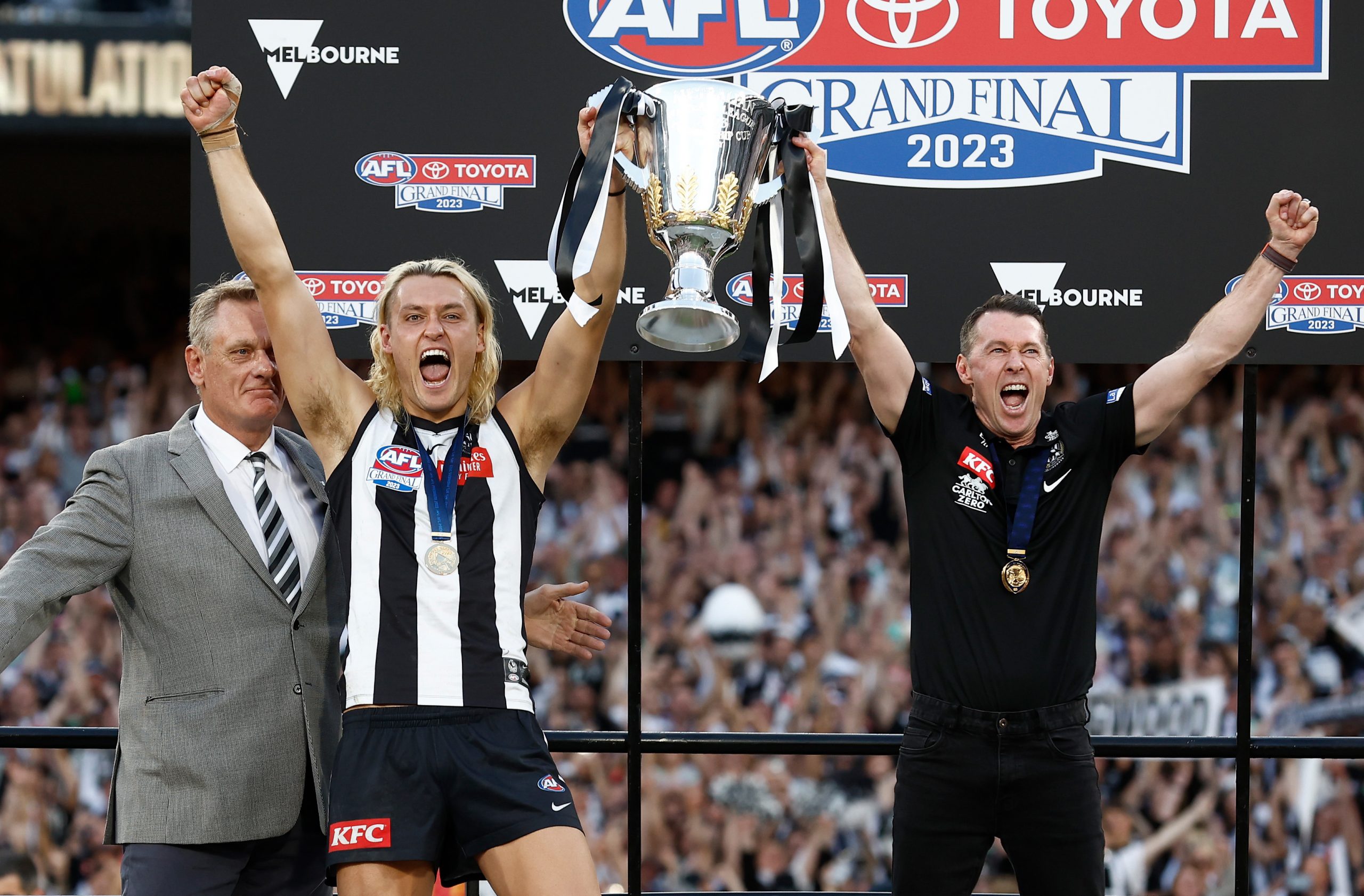 MELBOURNE, AUSTRALIA - SEPTEMBER 30: (L-R) Peter Moore, Darcy Moore of the Magpies and Craig McRae, Senior Coach of the Magpies hold the cup aloft during the 2023 AFL Grand Final match between the Collingwood Magpies and the Brisbane Lions at the Melbourne Cricket Ground on September 30, 2023 in Melbourne, Australia. (Photo by Michael Willson/AFL Photos via Getty Images)