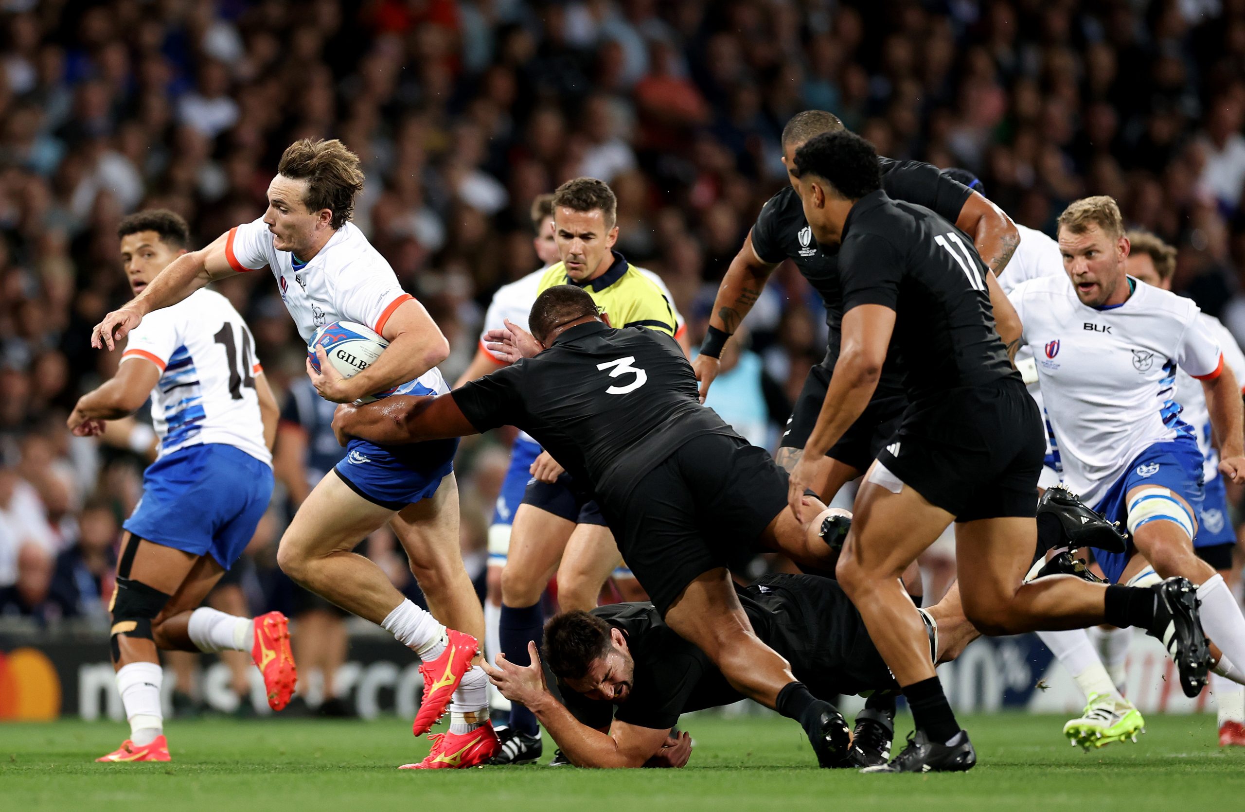 Le Roux Malan of Namibia is tackled by Nepo Laulala.