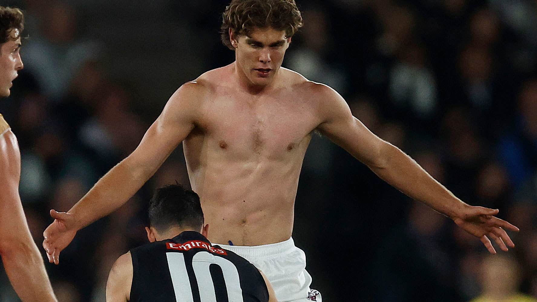 Deven Robertson of the Lions is seen after removing his torn guernsey during the round 23 AFL match between Collingwood Magpies and Brisbane Lions. 