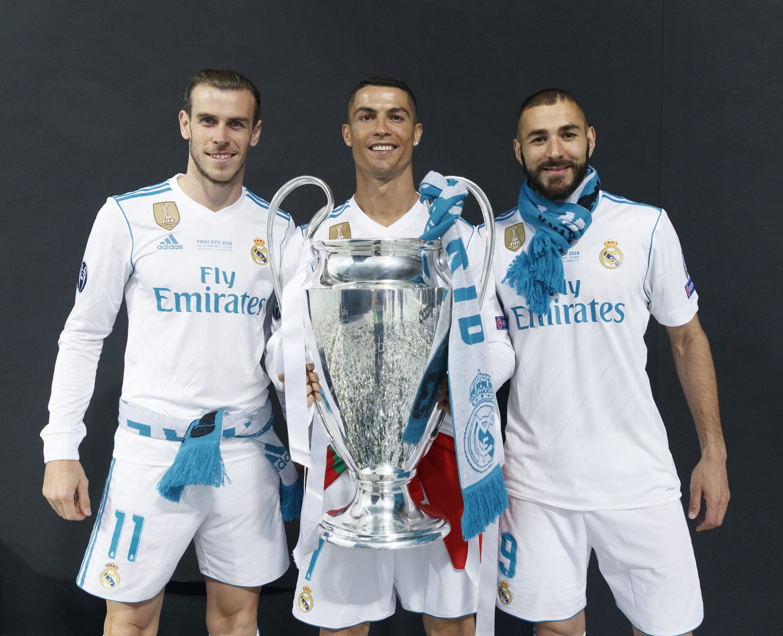 Real Madrid's Cristiano Ronaldo holds the trophy as he poses for a picture with his teammates Karim Benzema and Gareth Bale.