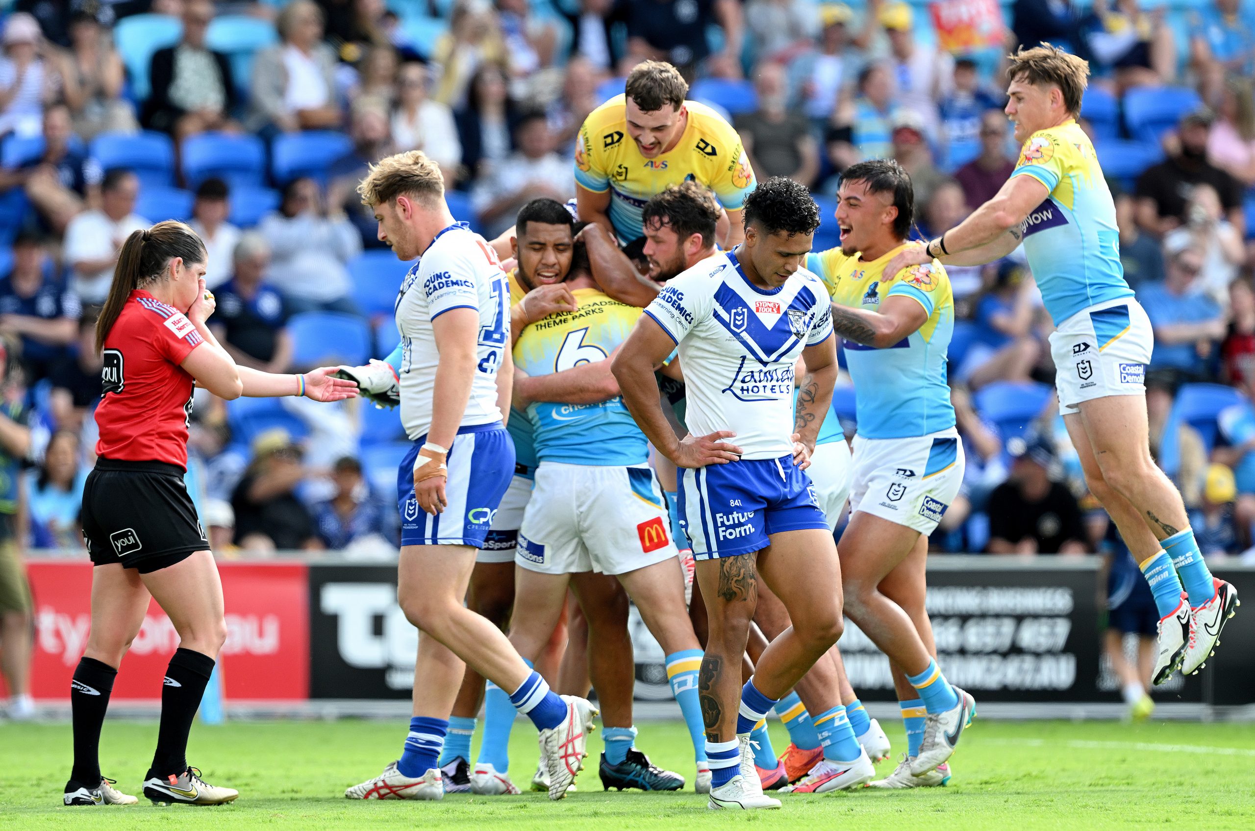 GOLD COAST, AUSTRALIA - SEPTEMBER 03: Referee Kasey Badger (L) awards the try as Kieran Foran of the Titans is congratulated by team mates after scoring a try during the round 27 NRL match between the Gold Coast Titans and Canterbury Bulldogs at Cbus Super Stadium on September 03, 2023 in Gold Coast, Australia. (Photo by Bradley Kanaris/Getty Images)