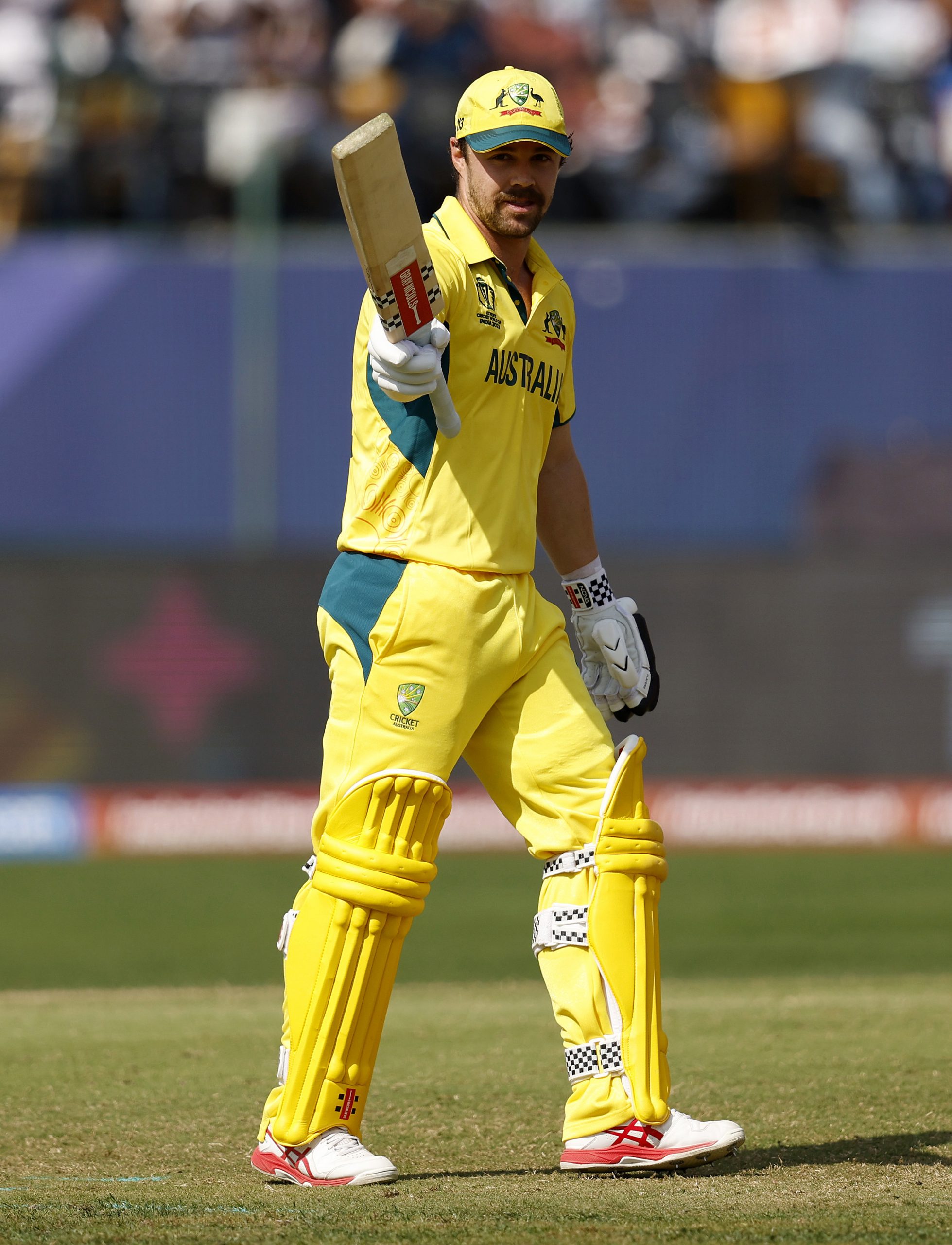 Travis Head of Australia celebrates as he raises his bat after reaching his century after scoring 100.