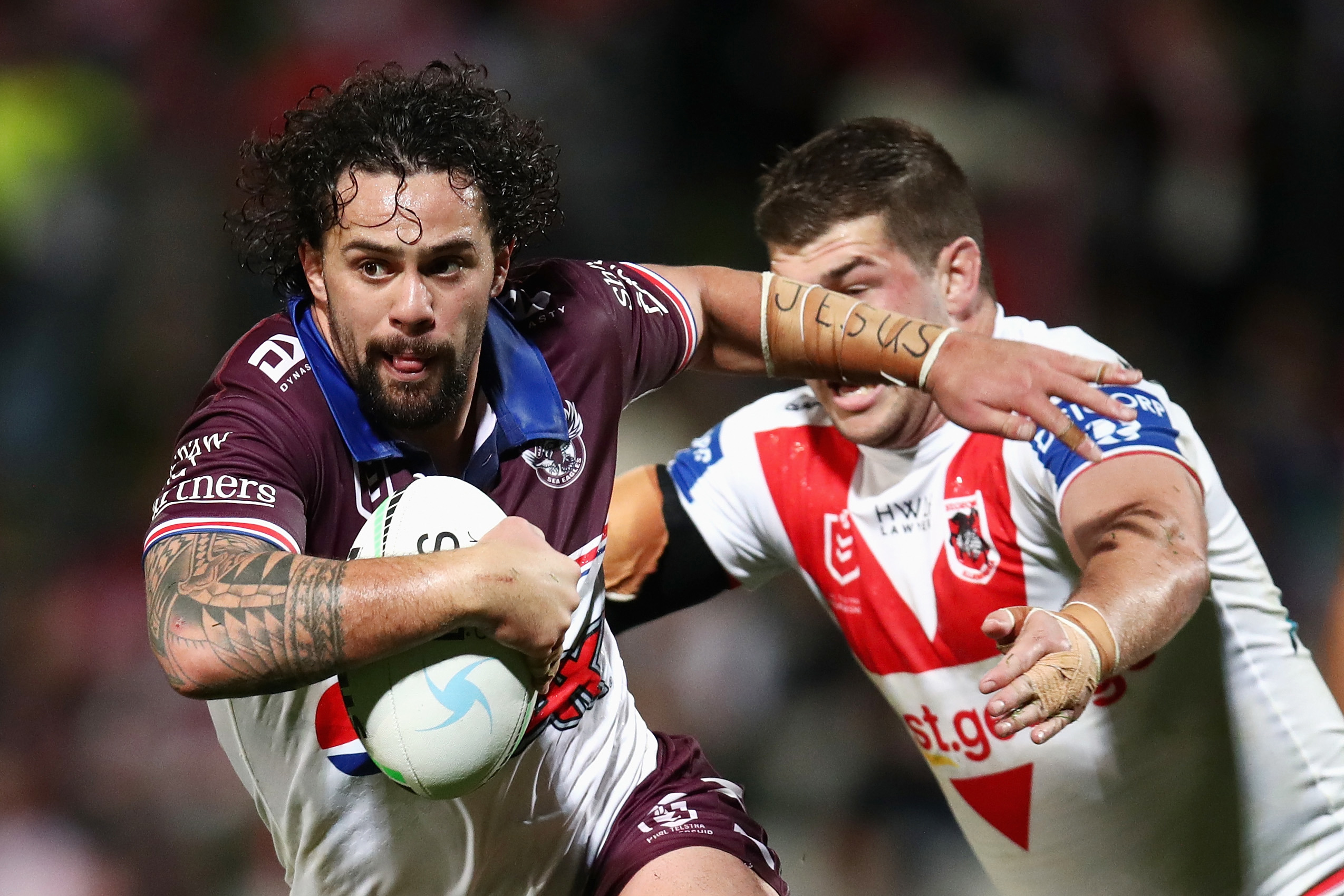 Josh Aloiai of the Sea Eagles is tackled during the 2022 round 19 NRL match between the St George Illawarra and Manly.