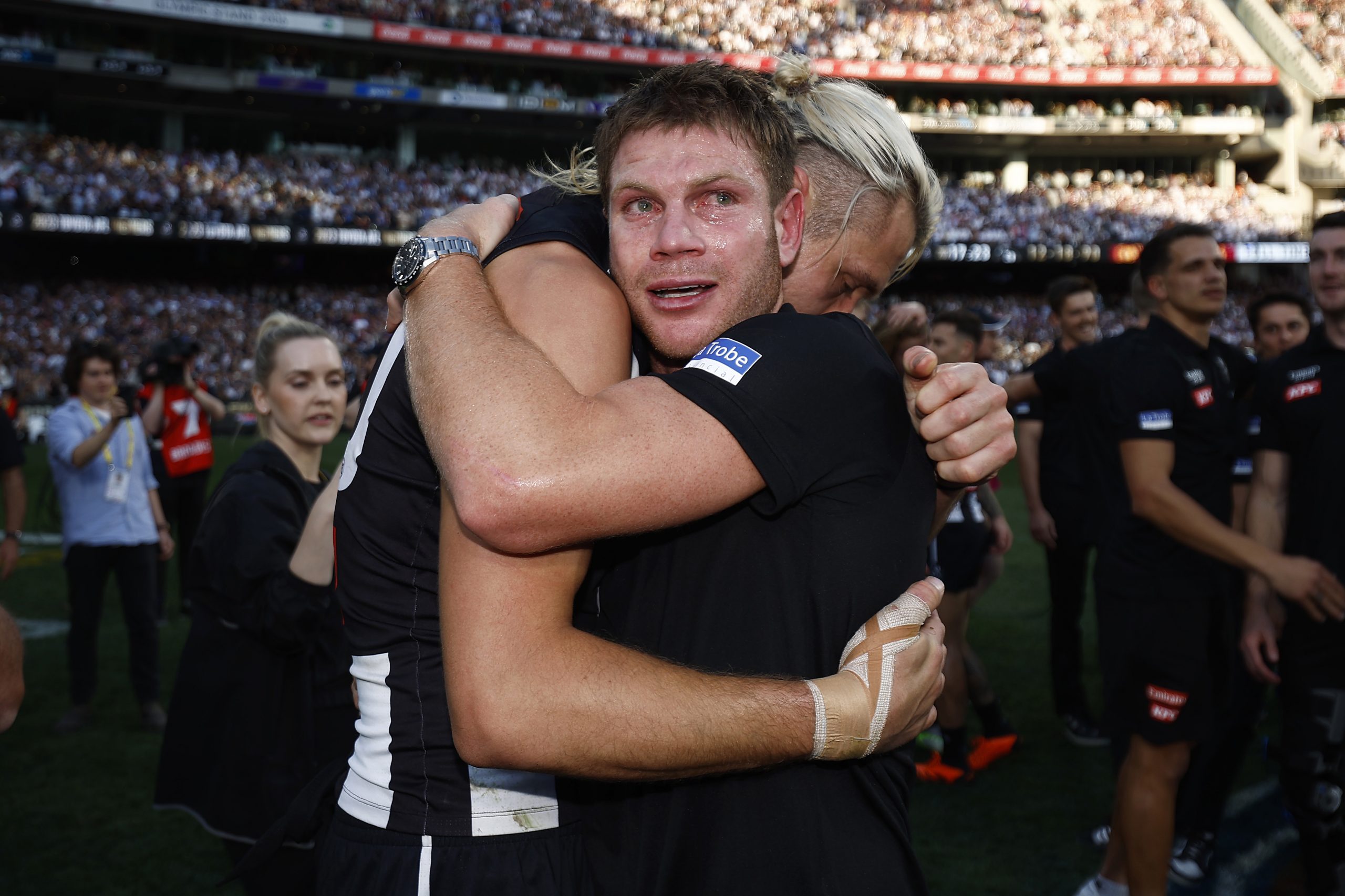 MELBOURNE, AUSTRALIA - SEPTEMBER 30: An emotional Taylor Adams of the Magpies hugs Darcy Moore of the Magpies after the 2023 AFL Grand Final match between Collingwood Magpies and Brisbane Lions at Melbourne Cricket Ground, on September 30, 2023, in Melbourne, Australia. (Photo by Daniel Pockett/AFL Photos/via Getty Images)