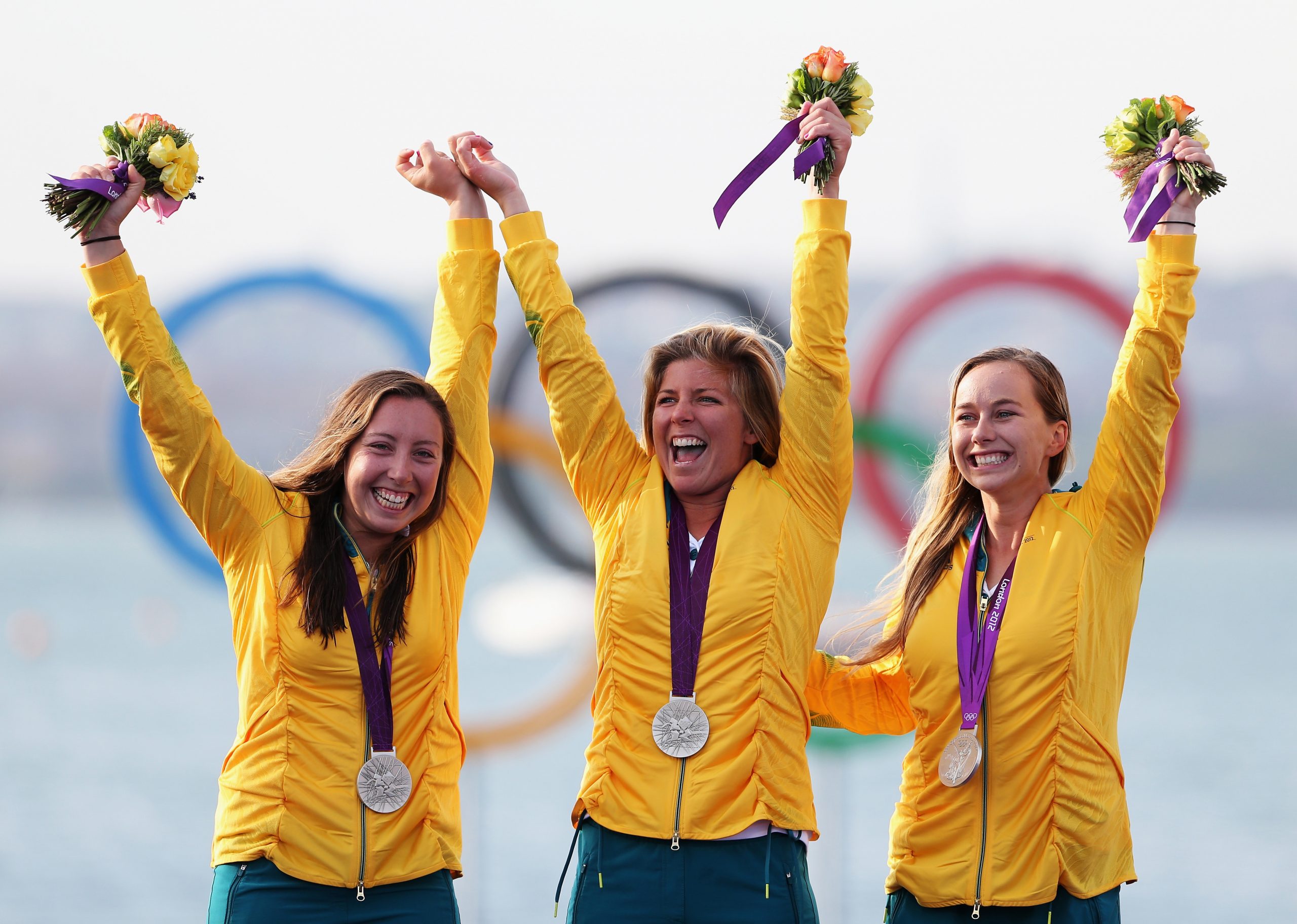 London 2012 silver medallists Nina Curtis, Lucinda Whitty and Olivia Price of Australia celebrate on the podium following the women's Elliott 6m match racing sailing.