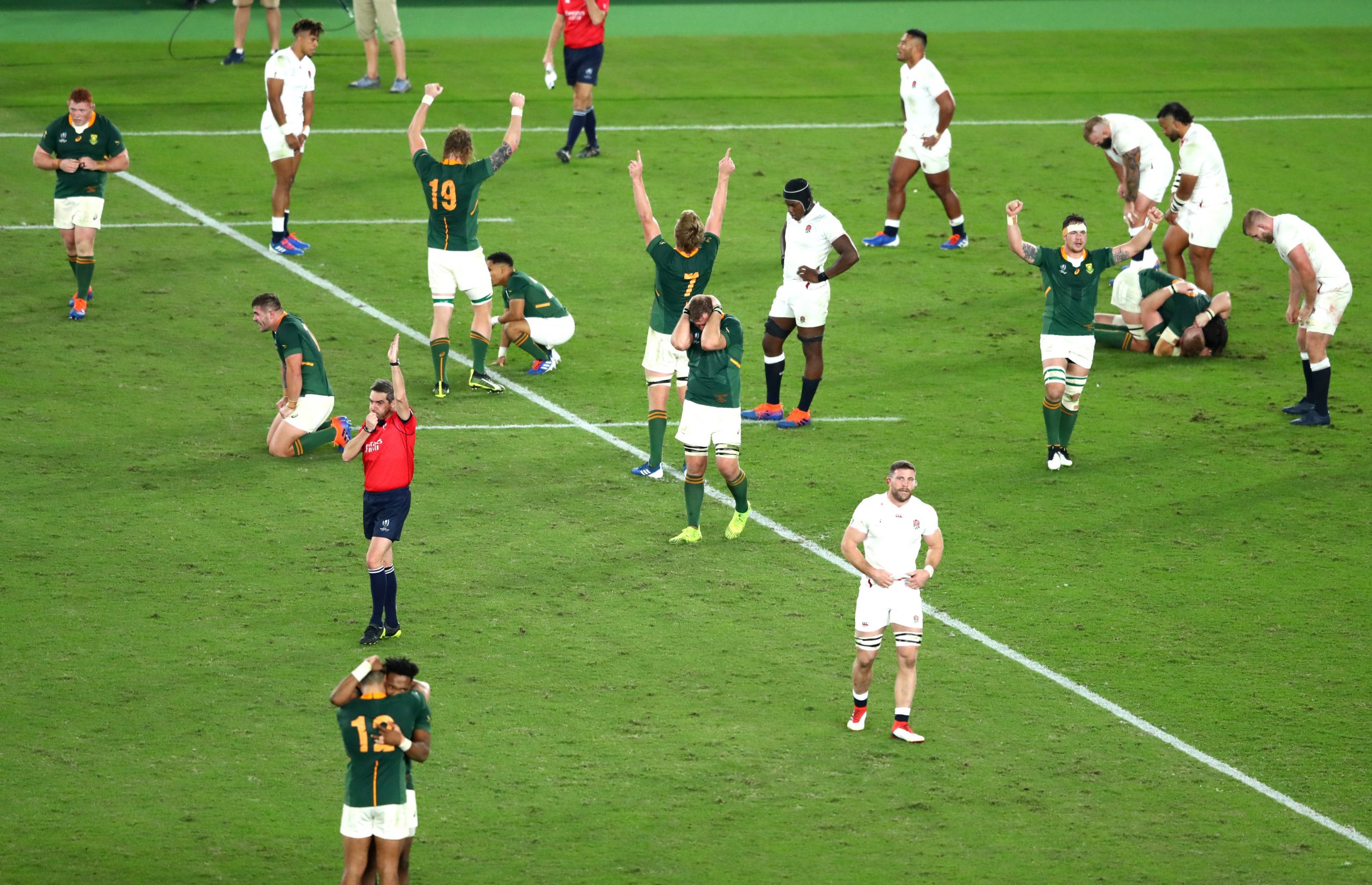 Players of South Africa celebrate victory as the England team react to defeat as referee Jerome Garces blows his whistle during the Rugby World Cup 2019 final.