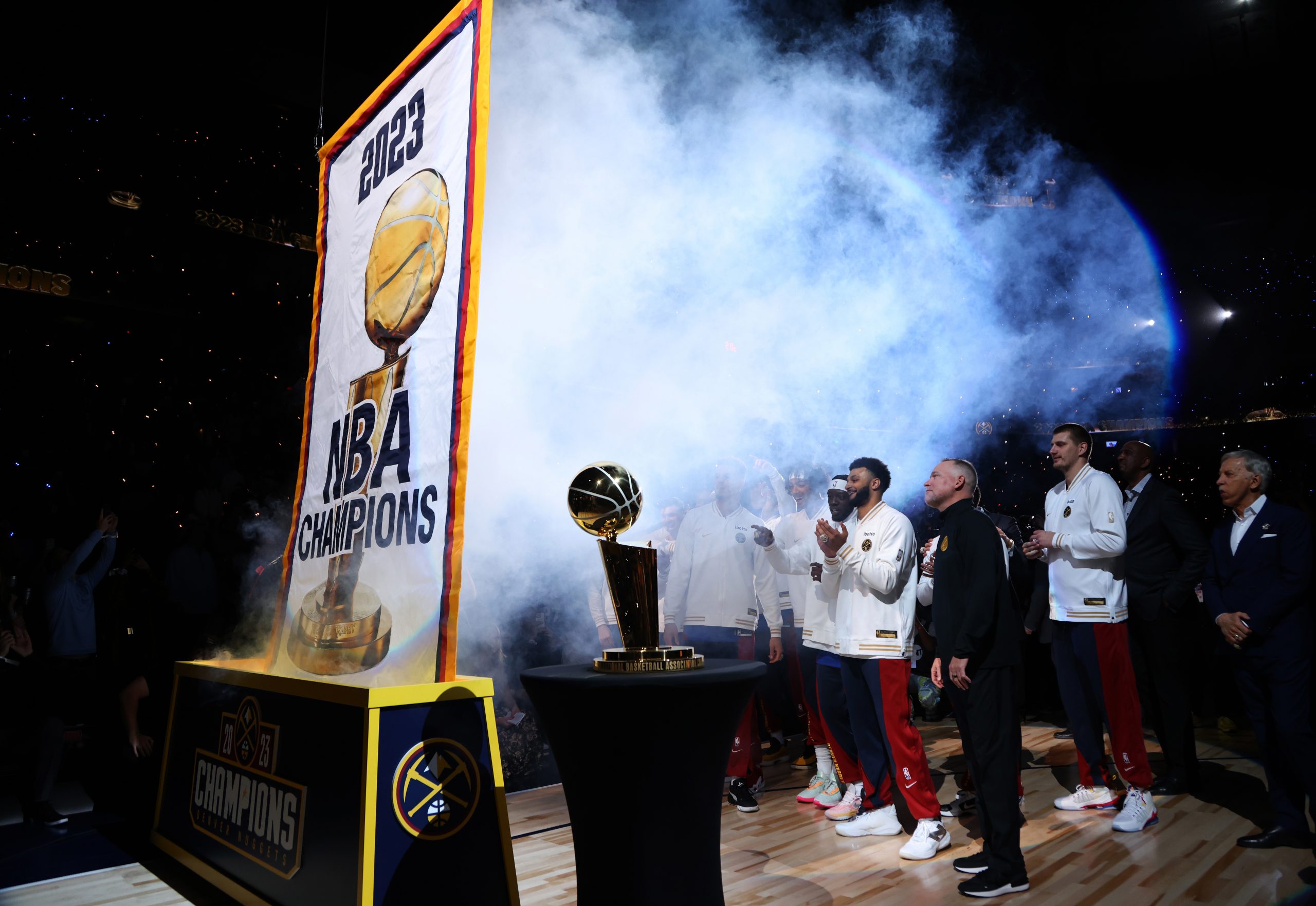 The Denver Nuggets players watch the championship banner before it gets raised to the rafters