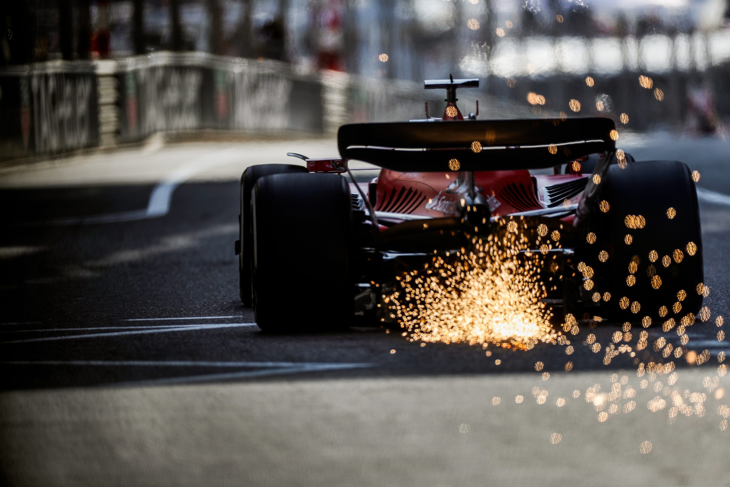 The bottom of Charles Leclerc's Ferrari creates sparks as it goes over bumps.