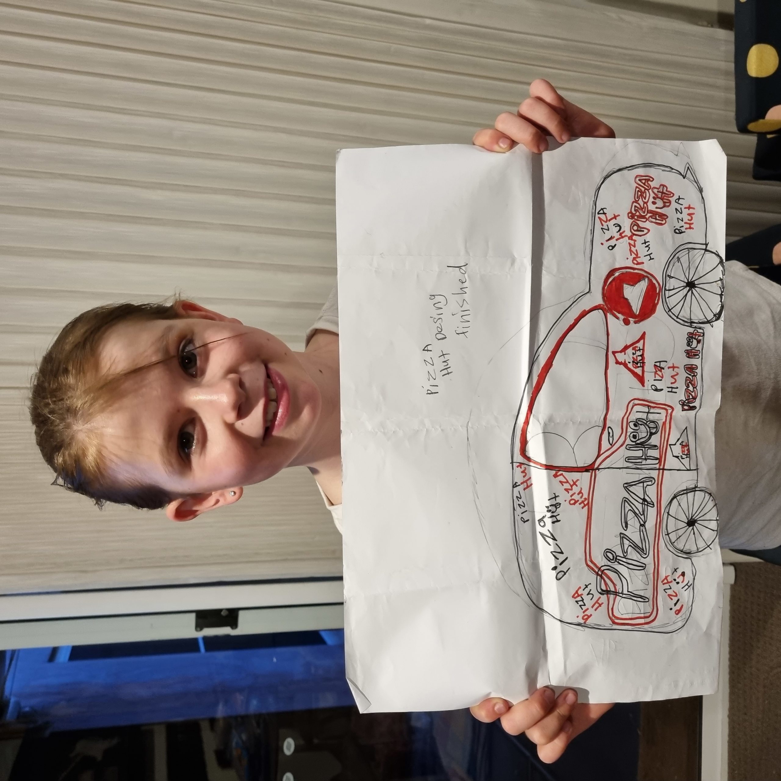 Grace Lewis with her drawing of Macauley Jones' Pizza Hut Camaro that will race at the Adelaide 500.