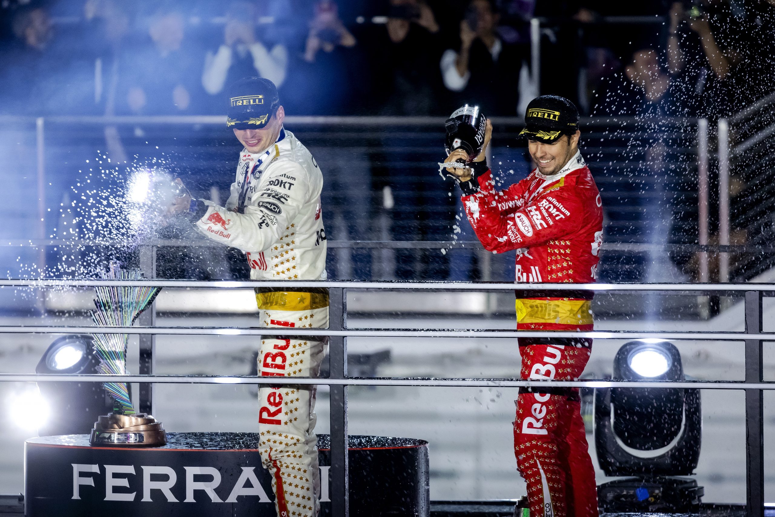 Max Verstappen and Sergio Perez celebrate on the podium after the Las Vegas Grand Prix.