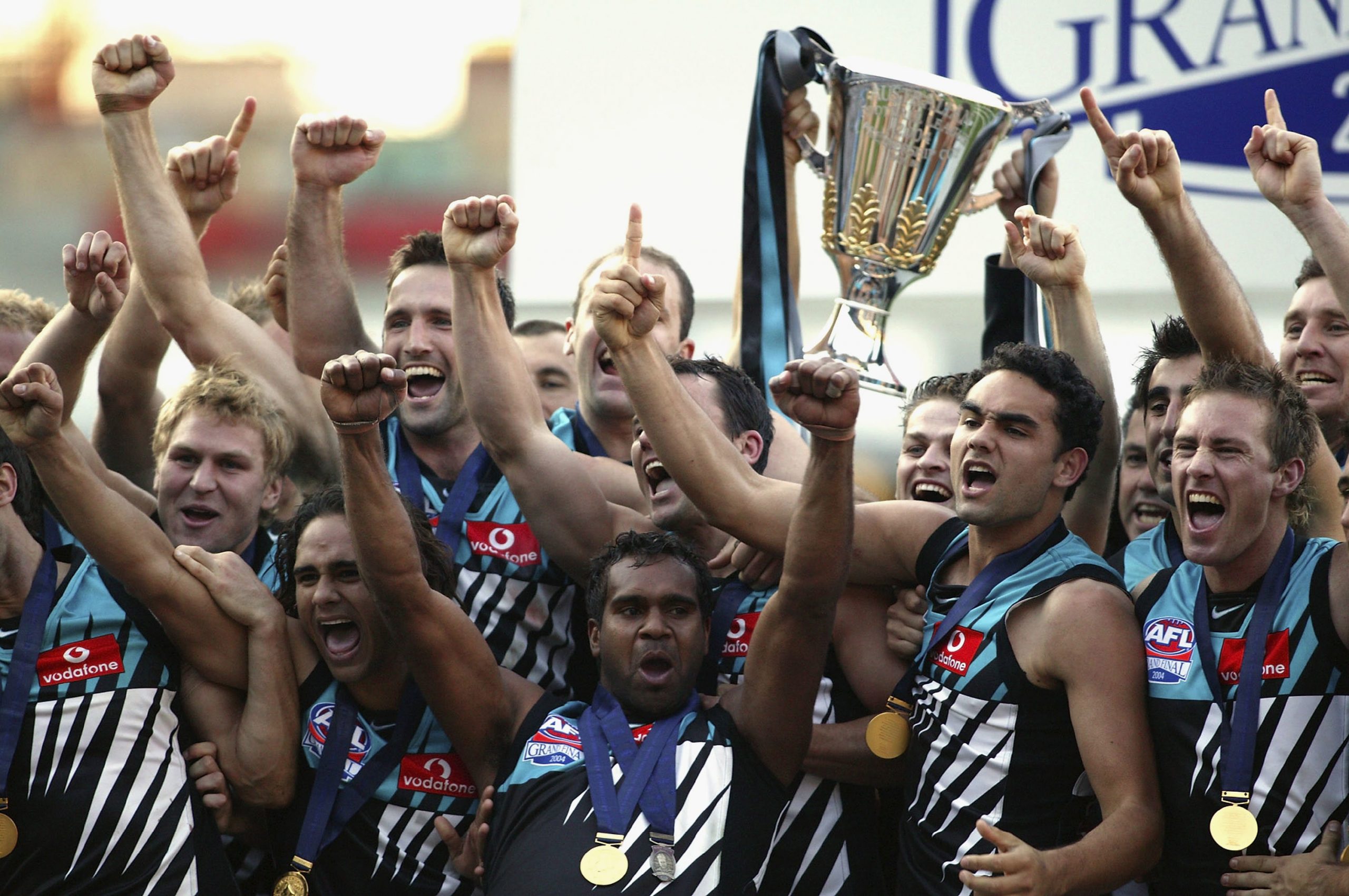 MELBOURNE, AUSTRALIA - SEPTEMBER 25:   Port Adelaide celebrate with the cup after the AFL Grand Final between the Port Adelaide Power and the Brisbane Lions at the Melbourne Cricket Ground September 25, 2004 in Melbourne, Australia. (Photo by Tony Lewis/Getty Images)