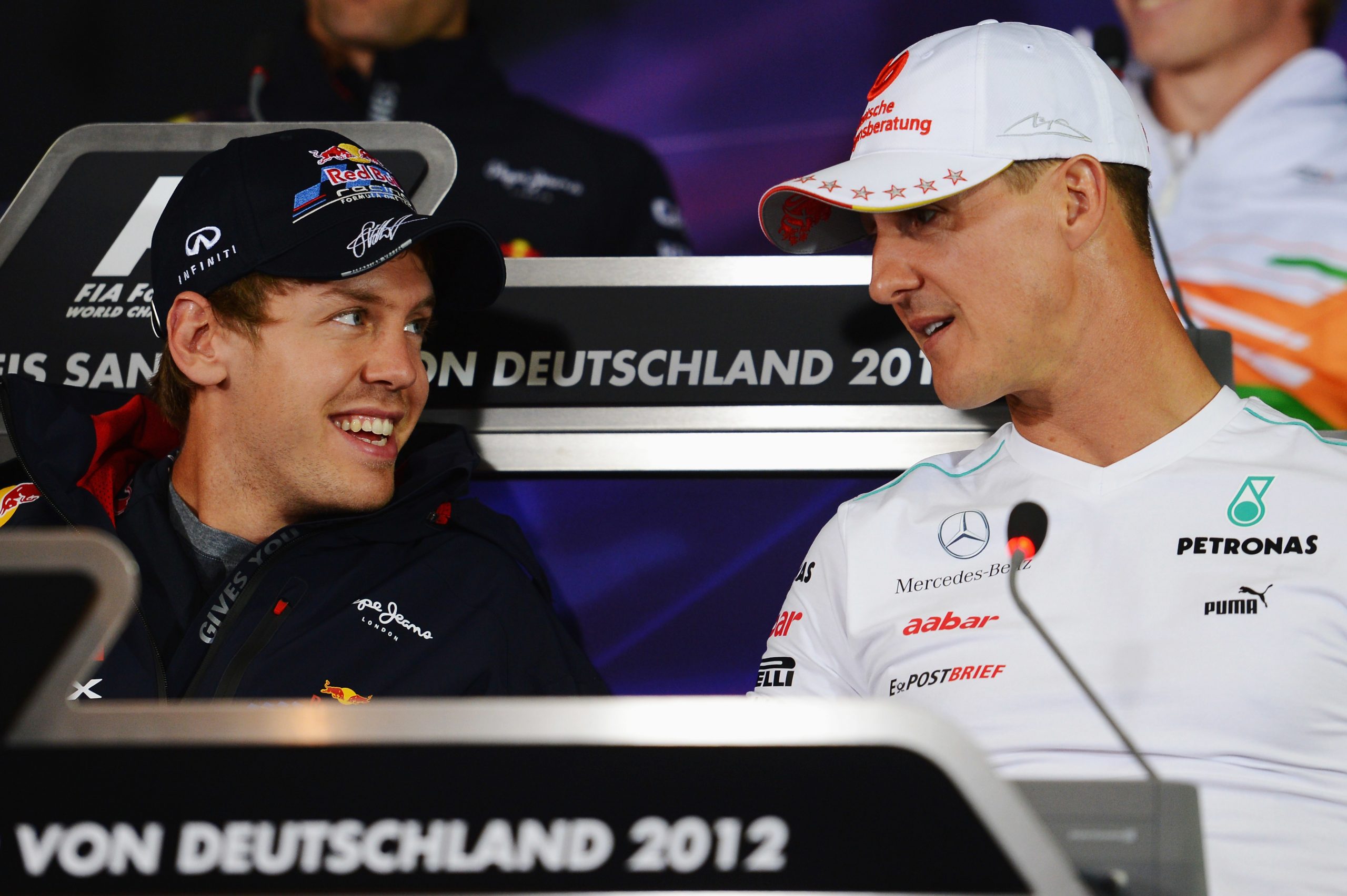 Sebastian Vettel (left) and Michael Schumacher speak before the 2012 German Grand Prix.