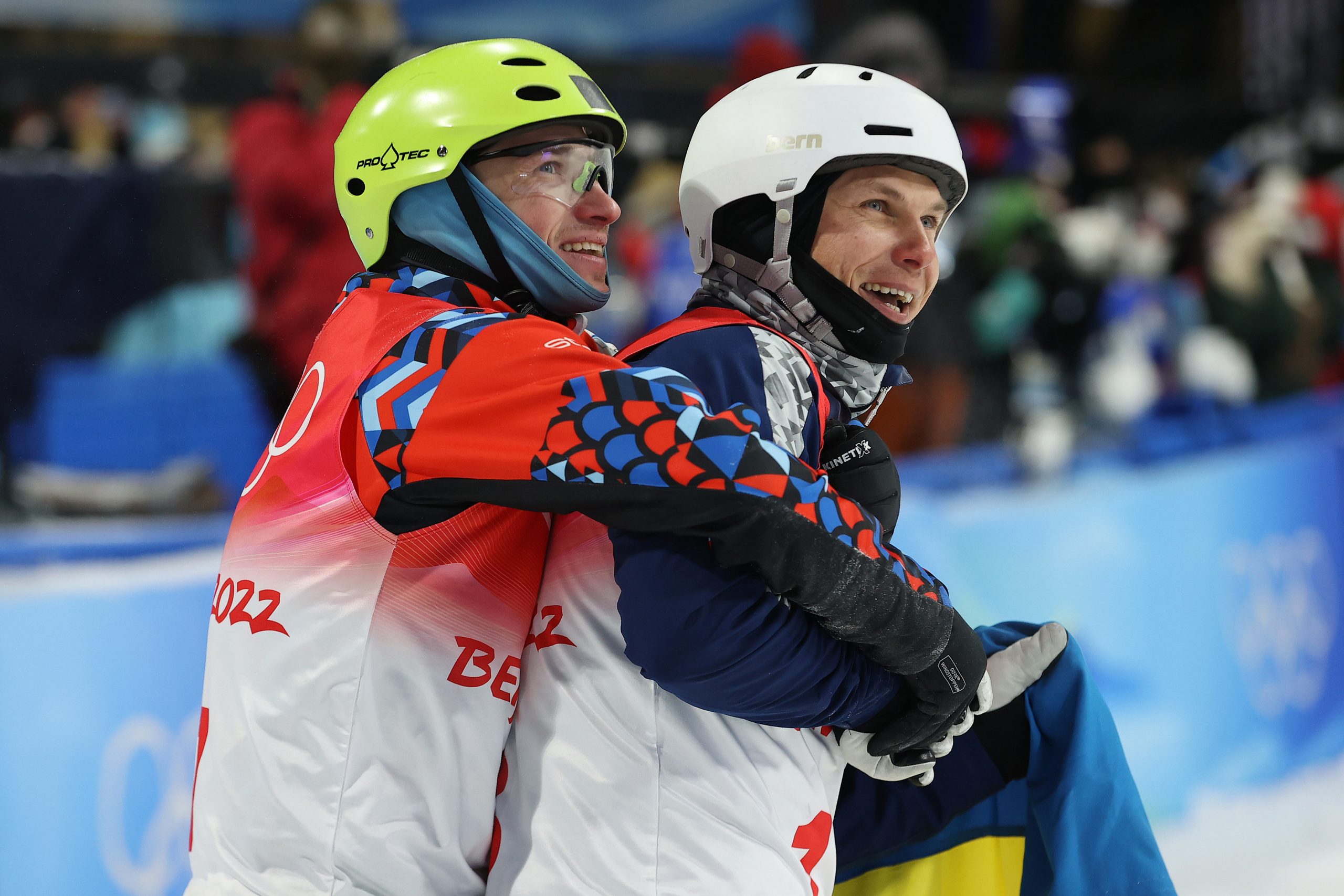 Bronze medallist Ilia Burov of Team ROC (L) and Silver medallist Oleksandr Abramenko of Team Ukraine (R) embrace during the men's freestyle skiing aerials final.