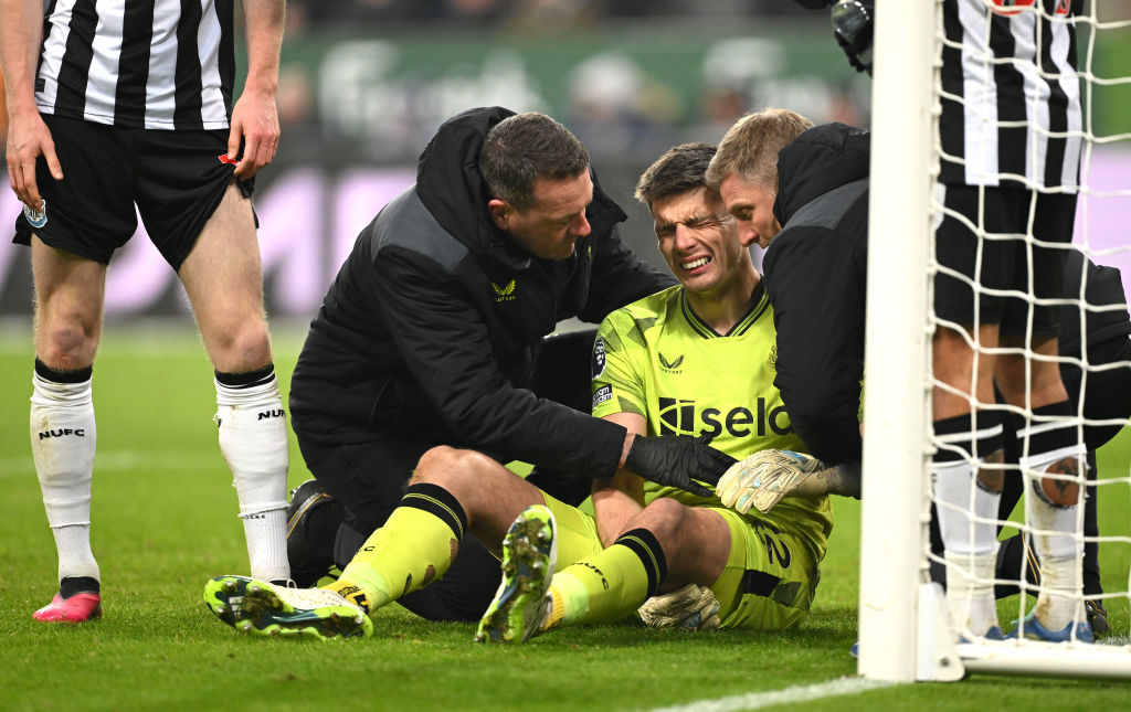 Newcastle United goalkeeper Nick Pope receives treatment for a shoulder injury which forces him to leave the field.