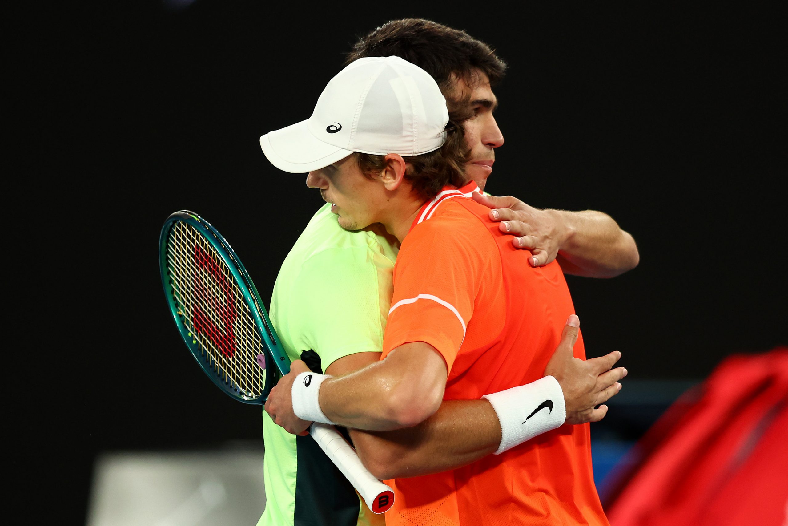 Alex de Minaur embraces Carlos Alcaraz of Spain following a charity match ahead of the 2024 Australian Open.