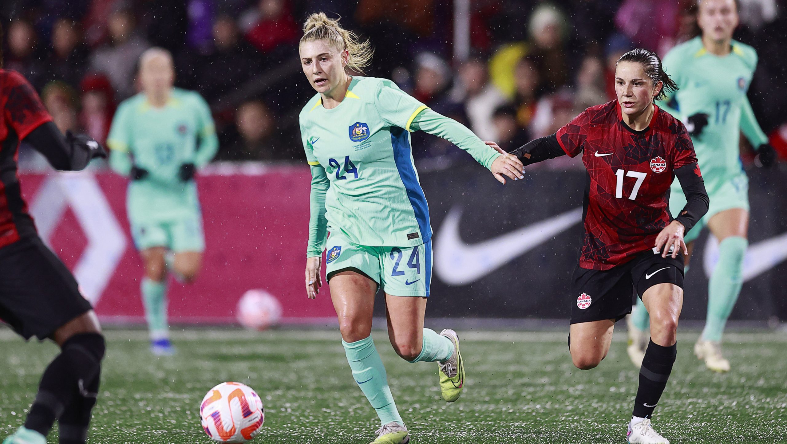 Australia's Remy Siemsen on the ball as she holds off Canada's Jessie Fleming during the first half of their friendly match at Starlight Stadium on December 1, 2023 in Langford, British Columbia. Canada won 5-0. 
