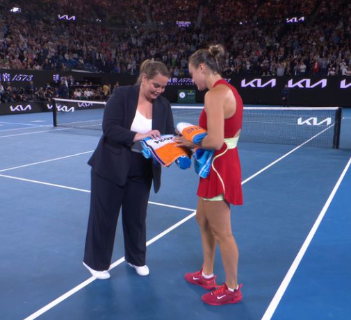 Jelena Dokic and Aryna Sabalenka sign towels.