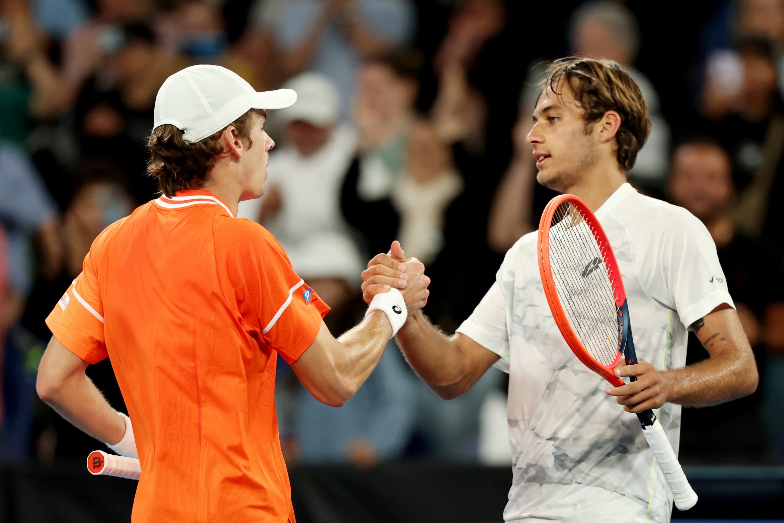 Alex de Minaur of Australia (left) embraces Flavio Cobolli of Italy after winning his round three singles match at the Australian Open.
